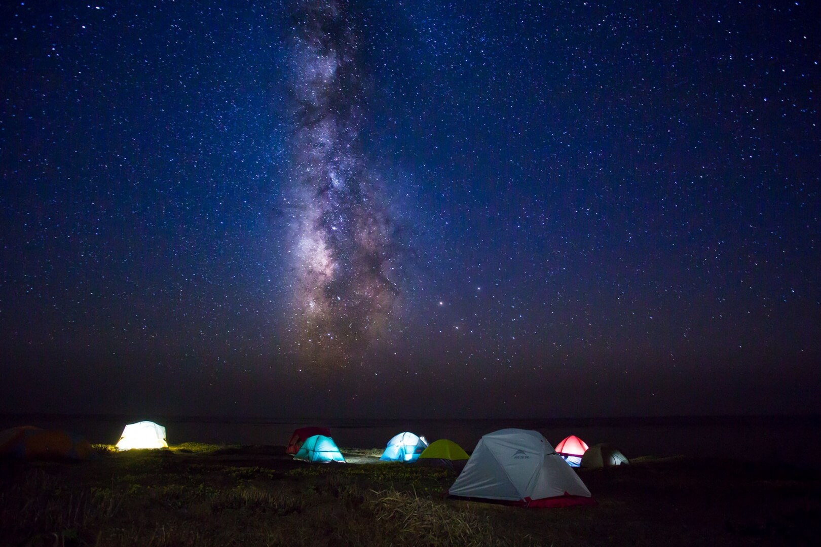 tents with stars above in the night sky