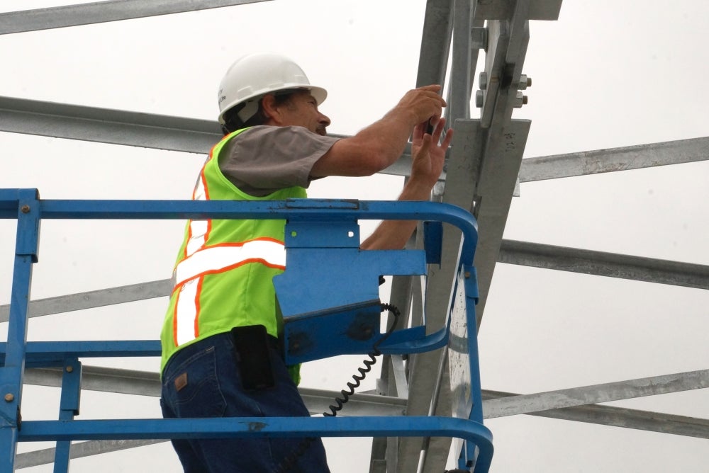 photo of man installing photovoltaic project