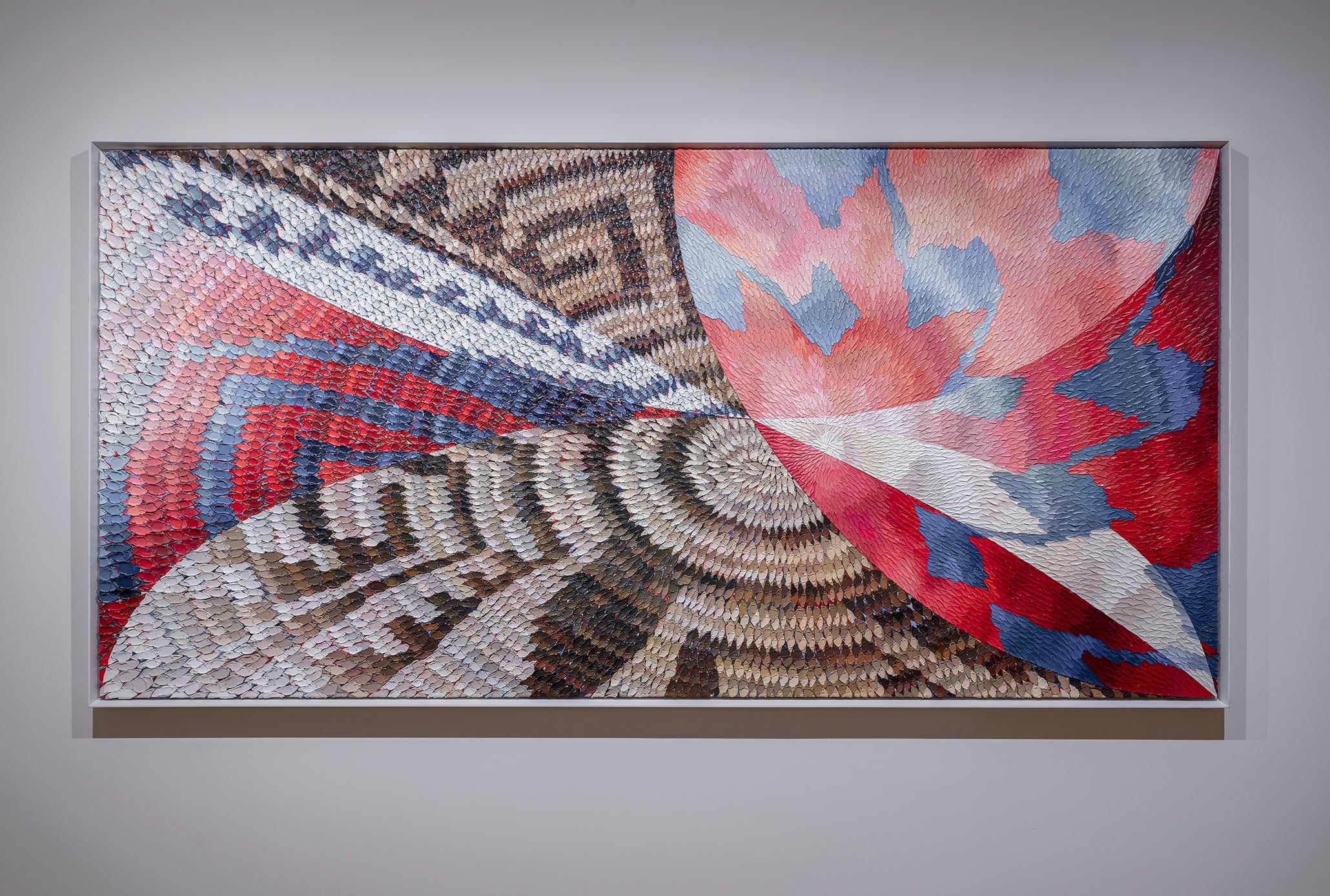 Large textile with various patterns is displayed in an art gallery