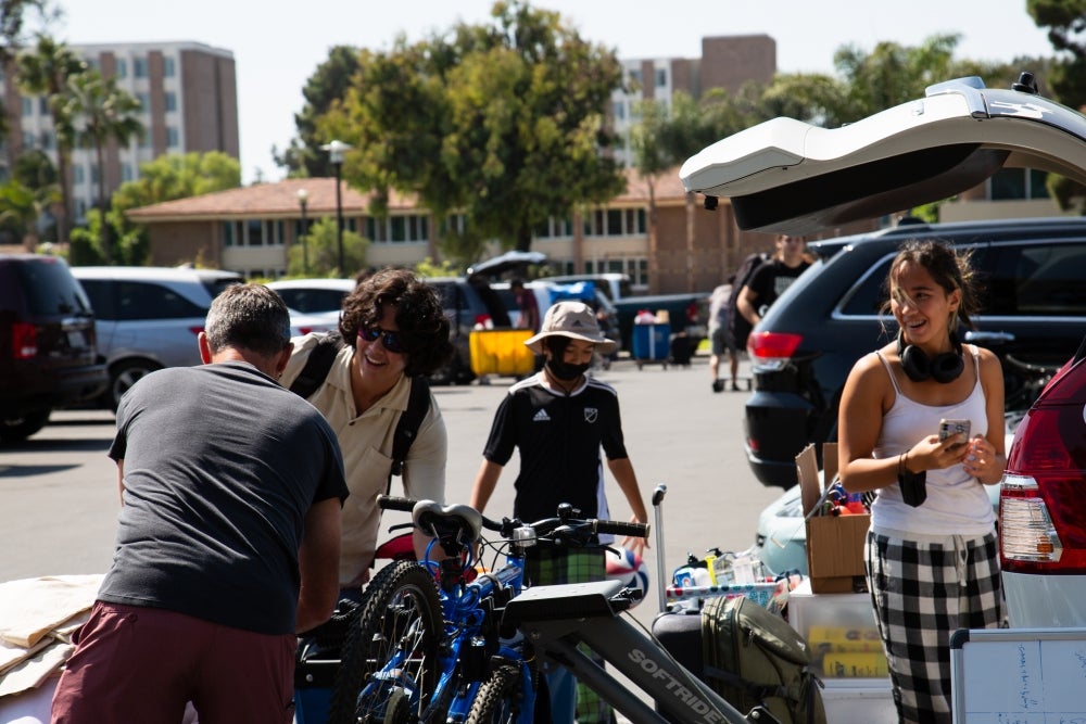 students and family getting luggage out of a car