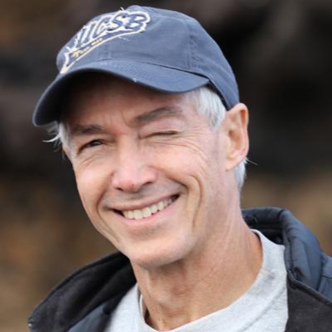 Mark Page winks, wearing a blue UCSB hat