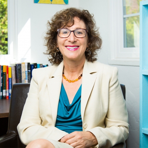 Alison Brysk sits in her office wearing a beige blazer