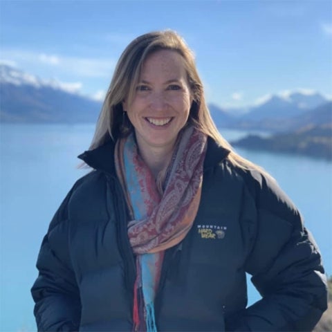 Caitlin Casey wears a puffy coat in front of a lake