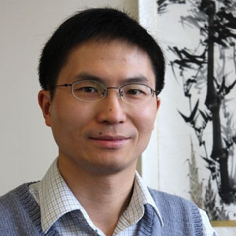 Liming Zhang wears a checkered white collared shirt under a blue vest