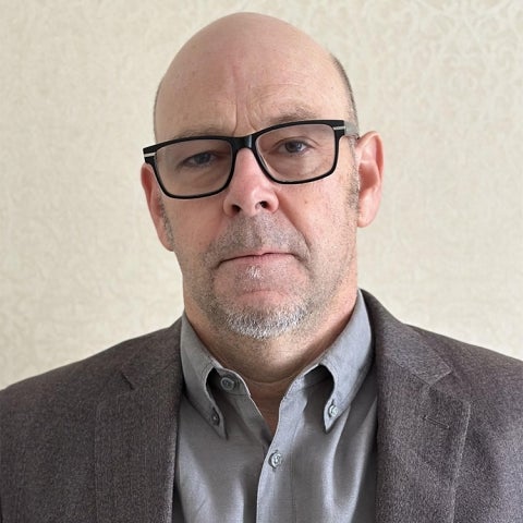 Douglas Kennett wears a dark suit