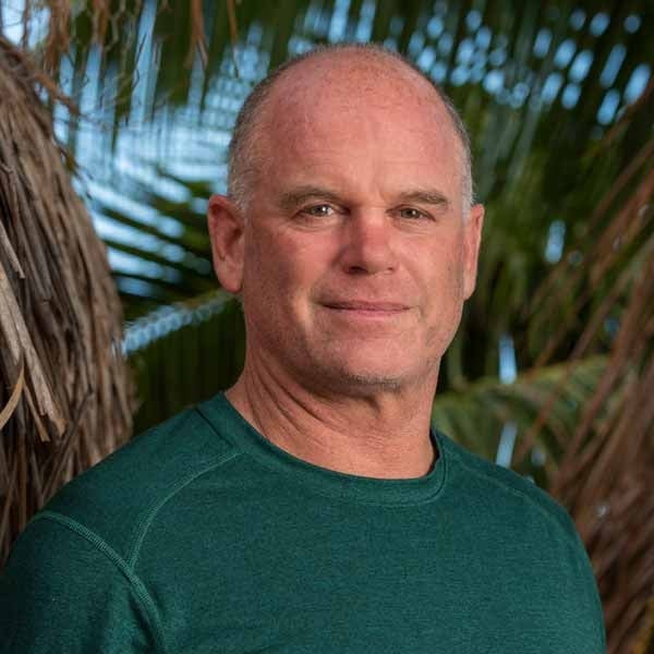 Hunter Lenihan with green shirt standing in front of forest