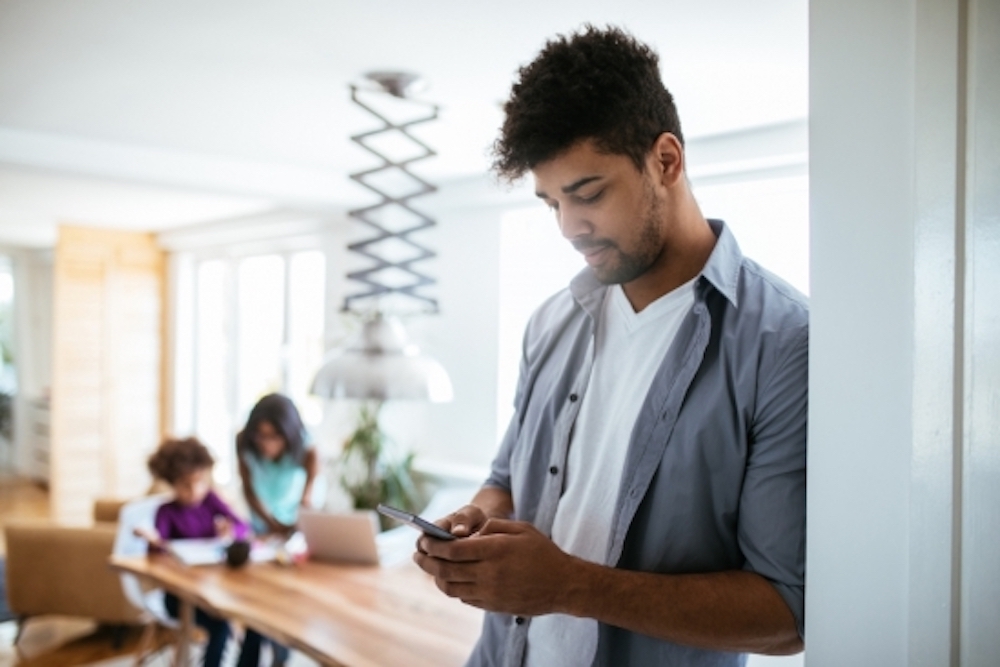 A man on his smartphone is distracted from his family.