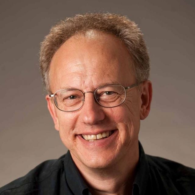 Joel Rothman wears glasses and a dark shirt