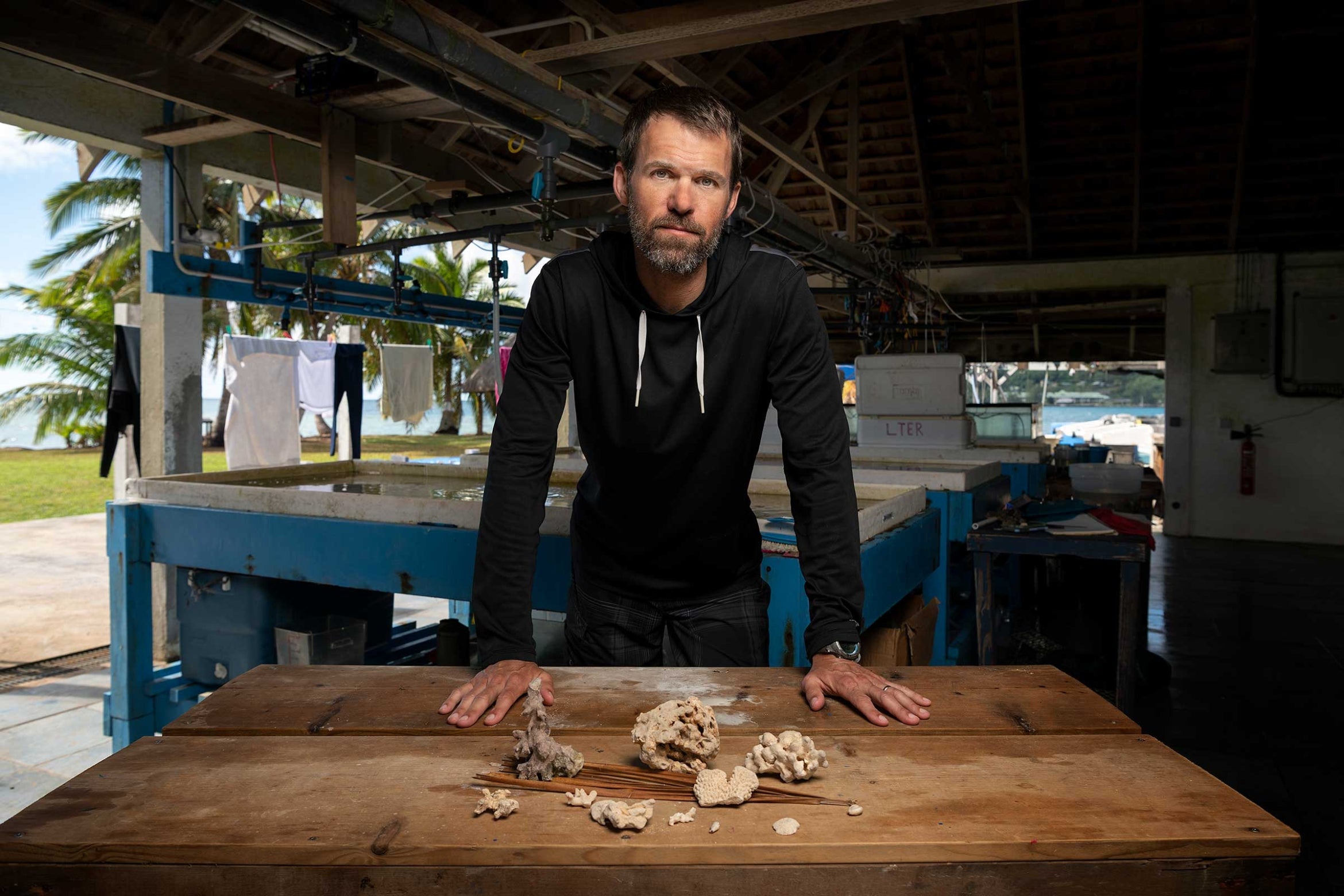 Deron Burkpile standing in front of wooden table