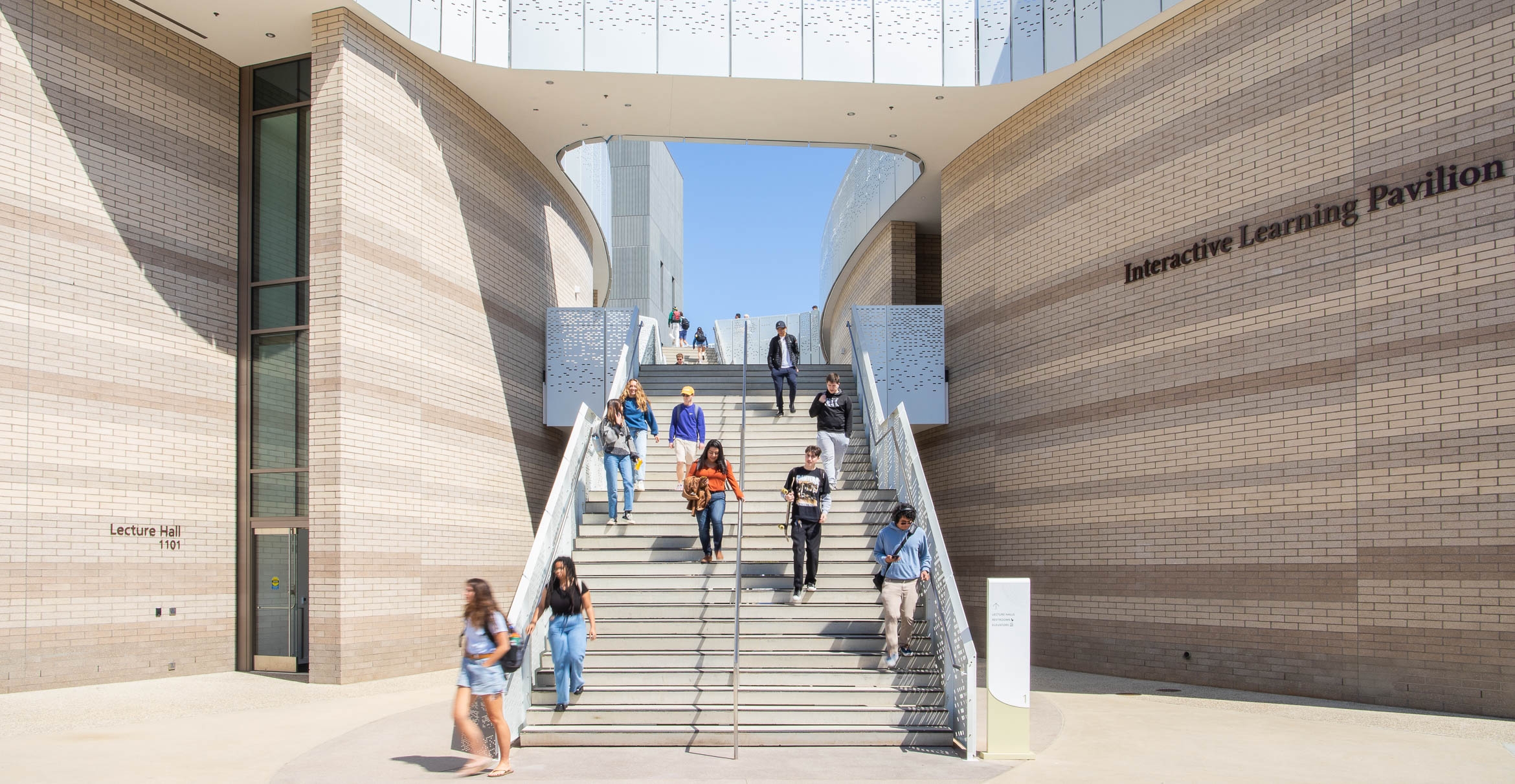 Students descend the building’s main staircase.