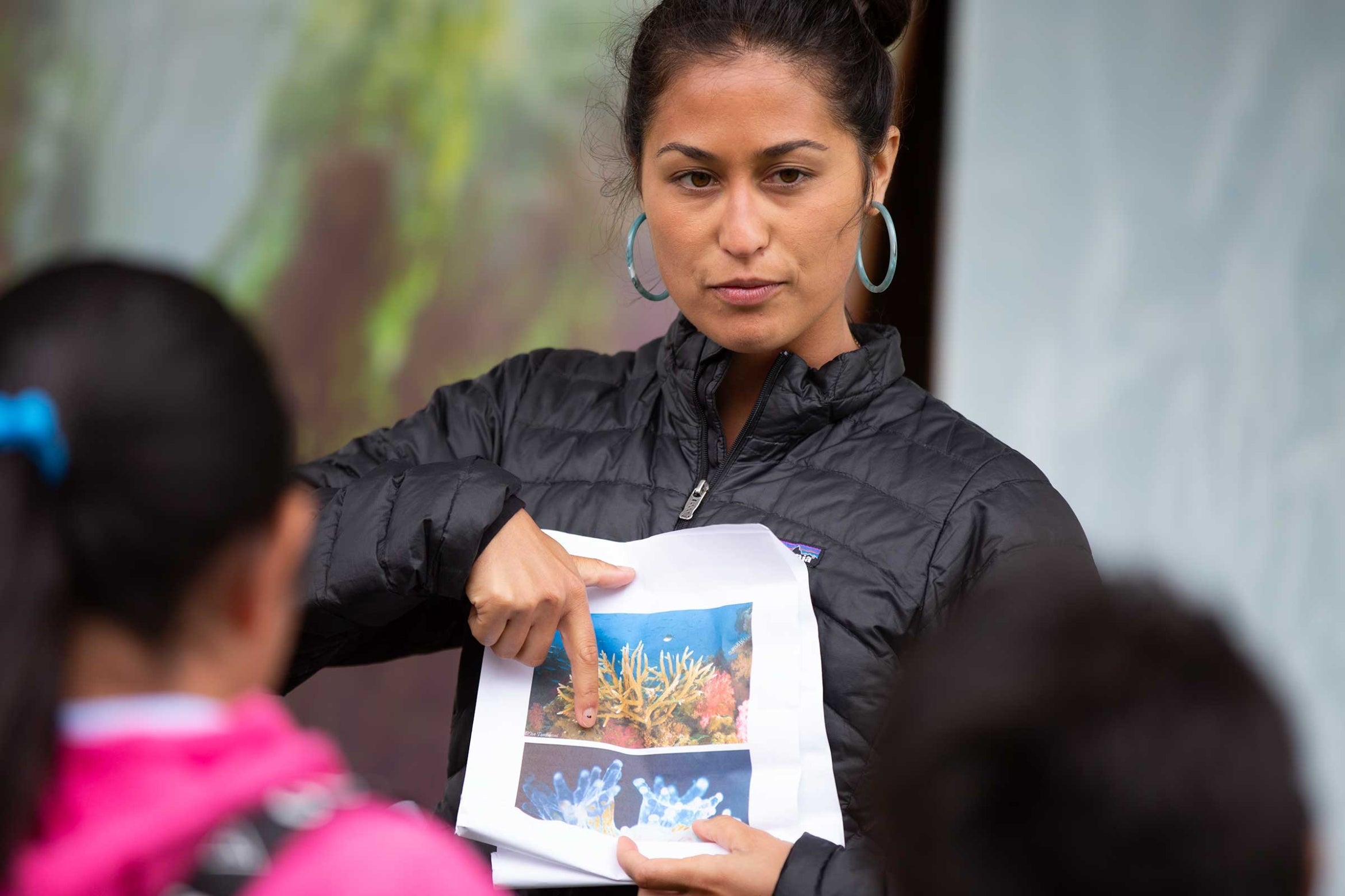 Dana Cook showing a photo on a paper to students