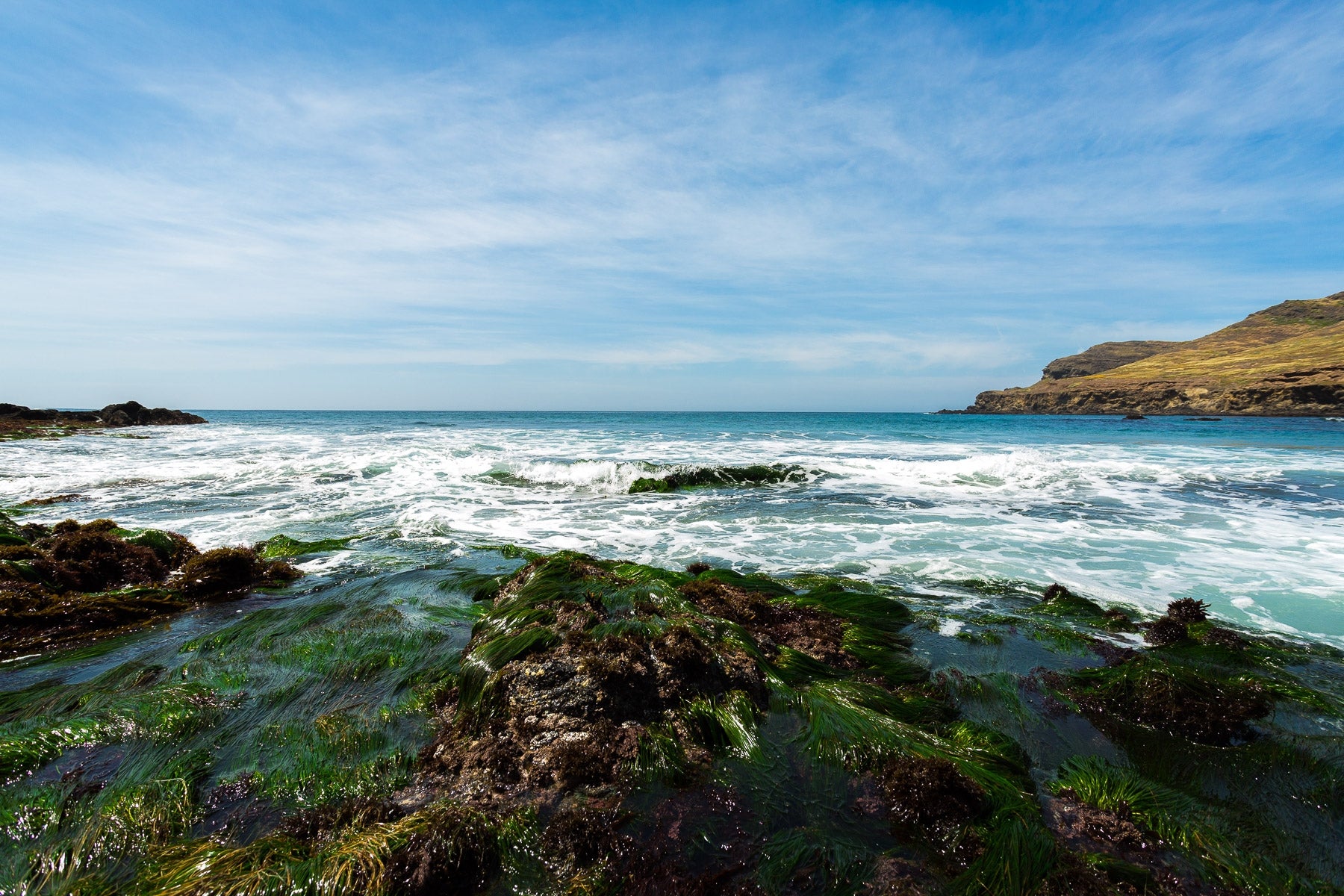 west side of the island coastline with waves crashing over rocks