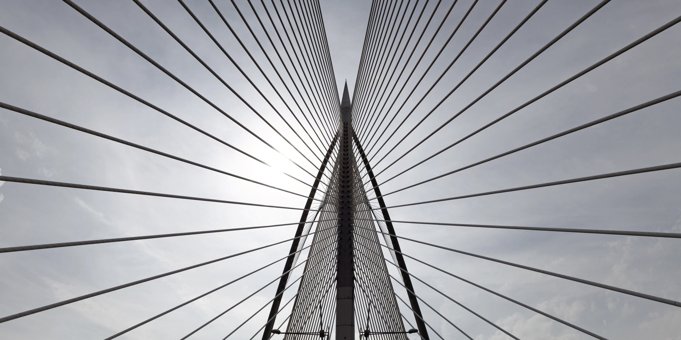 The symmetrical pattern of a cable-stayed bridge from below.