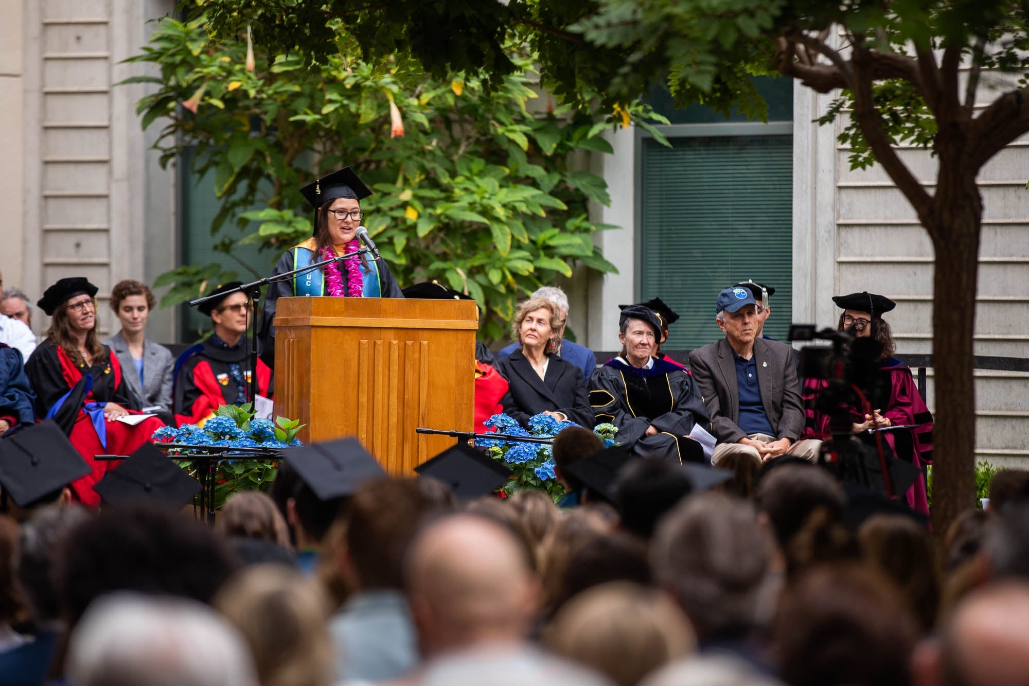 Abigail Sanford behind a lectern with professors behind her.