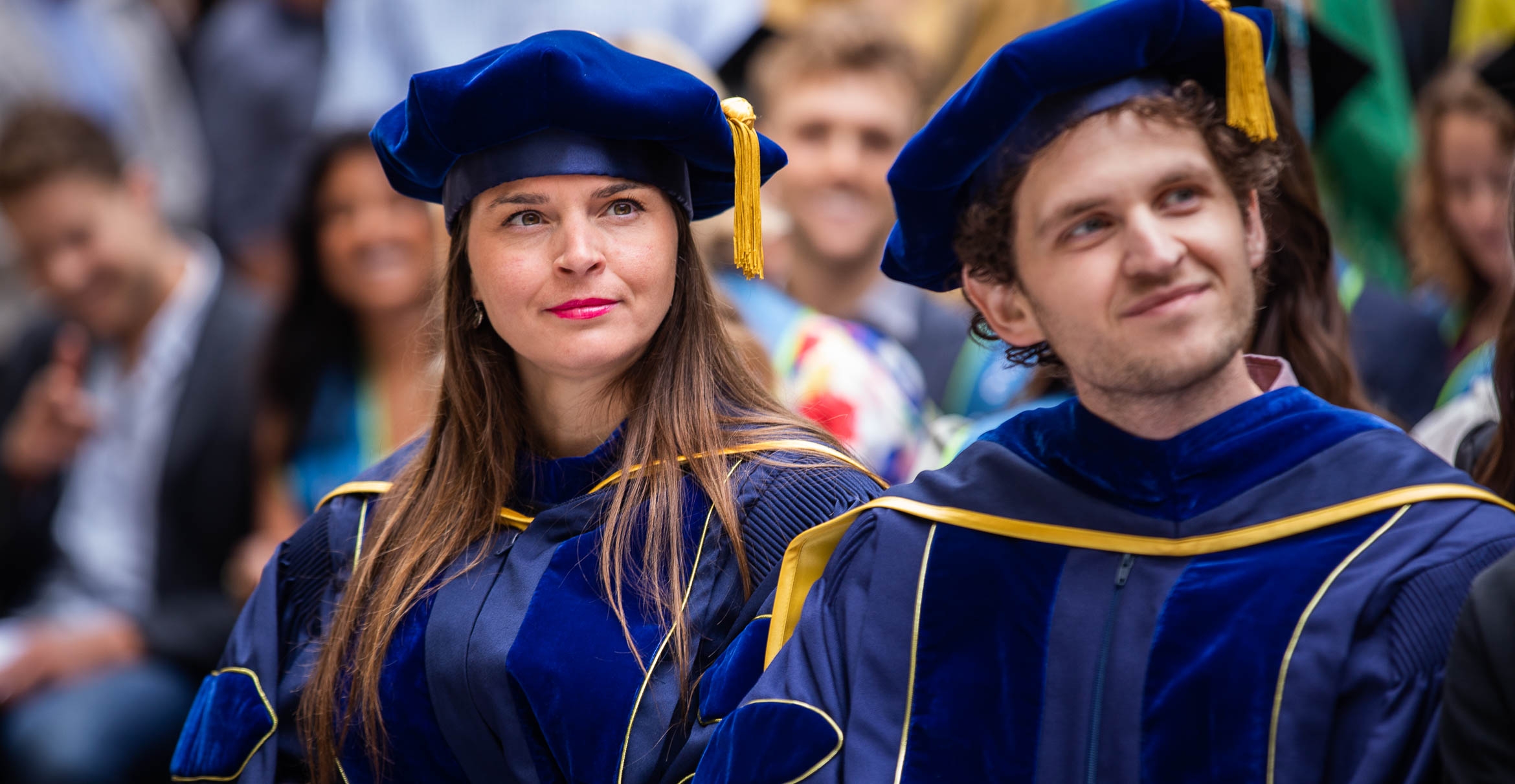 two students in blue commencement garb