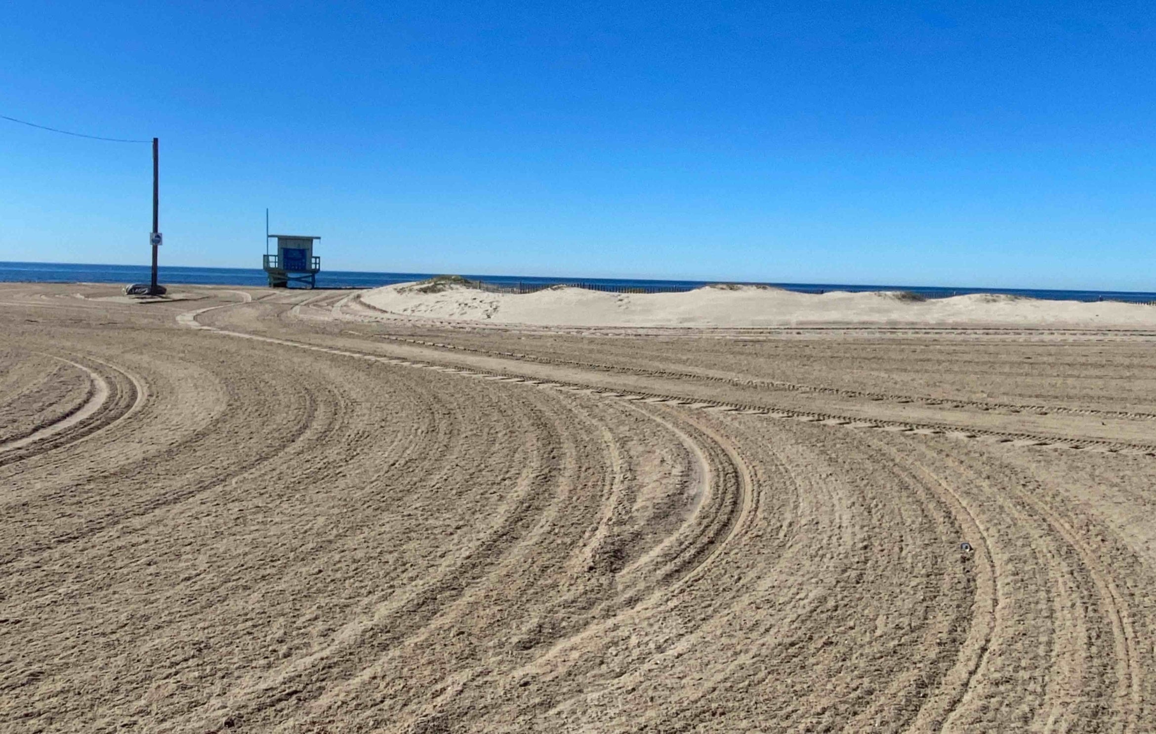 a flat beach landscape with the telltale lines left by raking