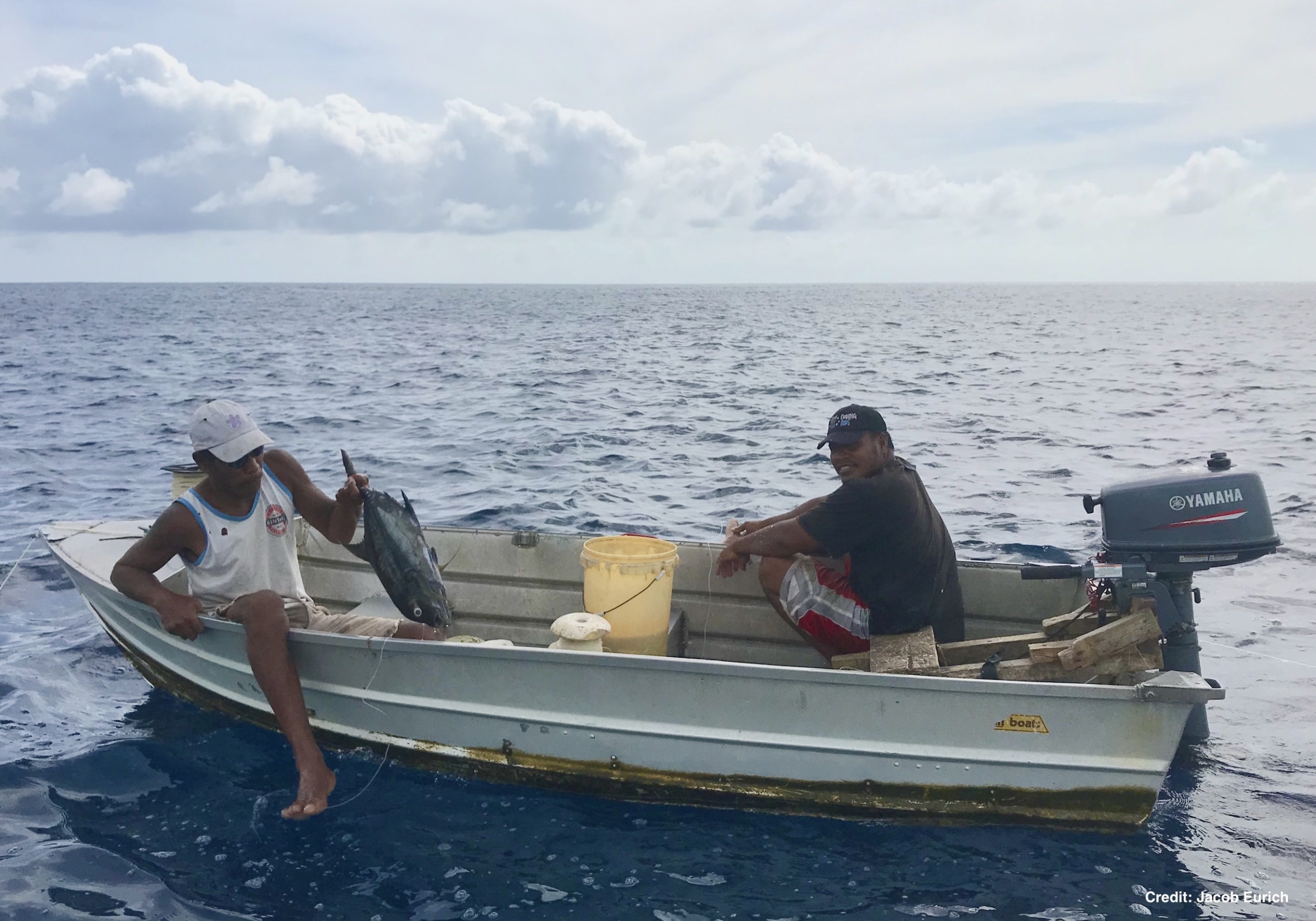 two fishermen in a small motorboat in the Pacific