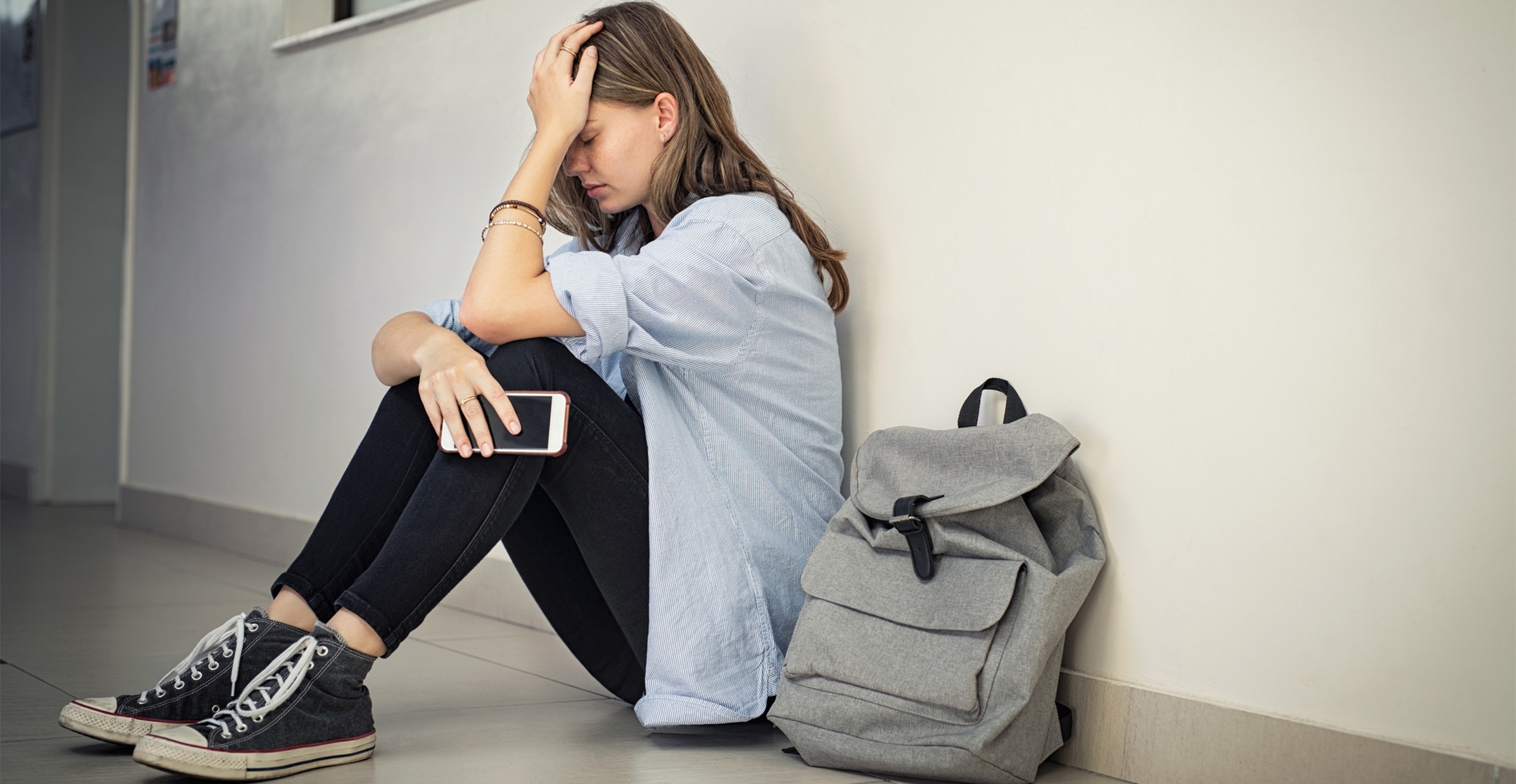 stock photograph of a teenage female at school experiencing sadness 