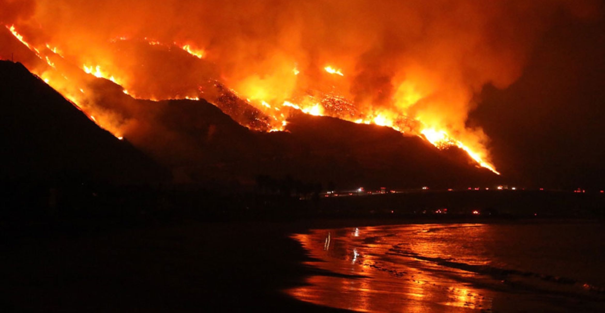 Flames from the Thomas Fire reflect in the waves at night.