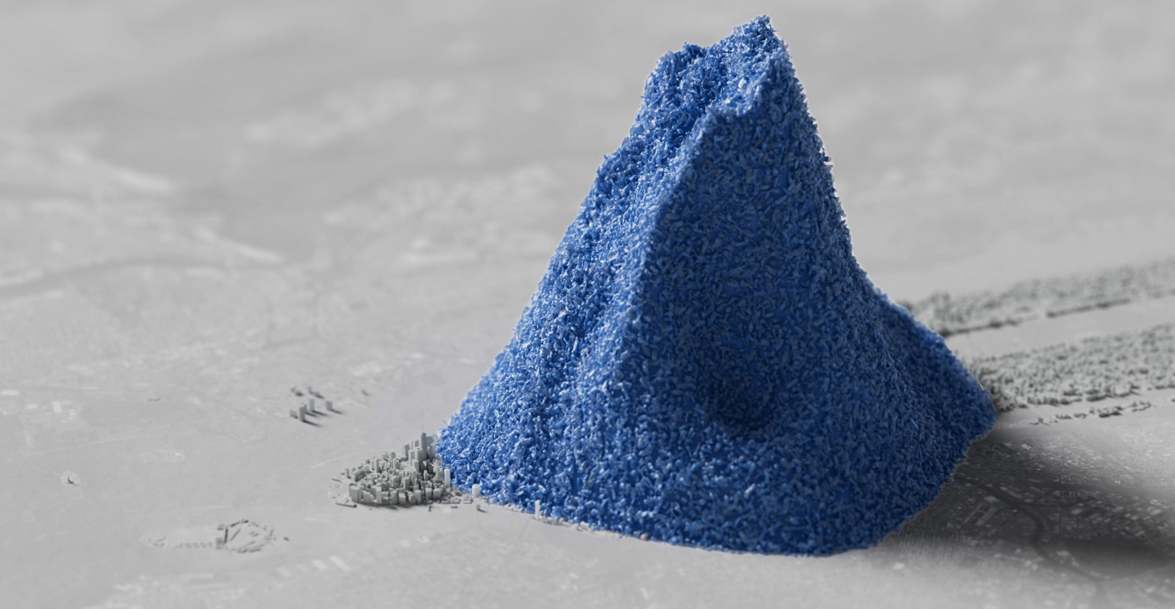 A large pile of small blue plastic objects rises from a relief map of Manhattan
