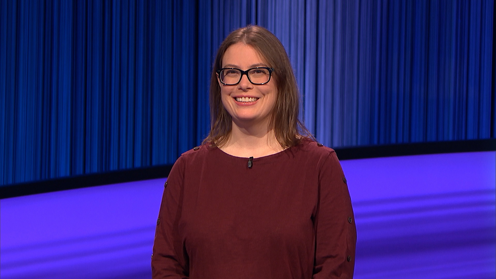 kristen thomas-mcgill white woman with glasses on blue stage