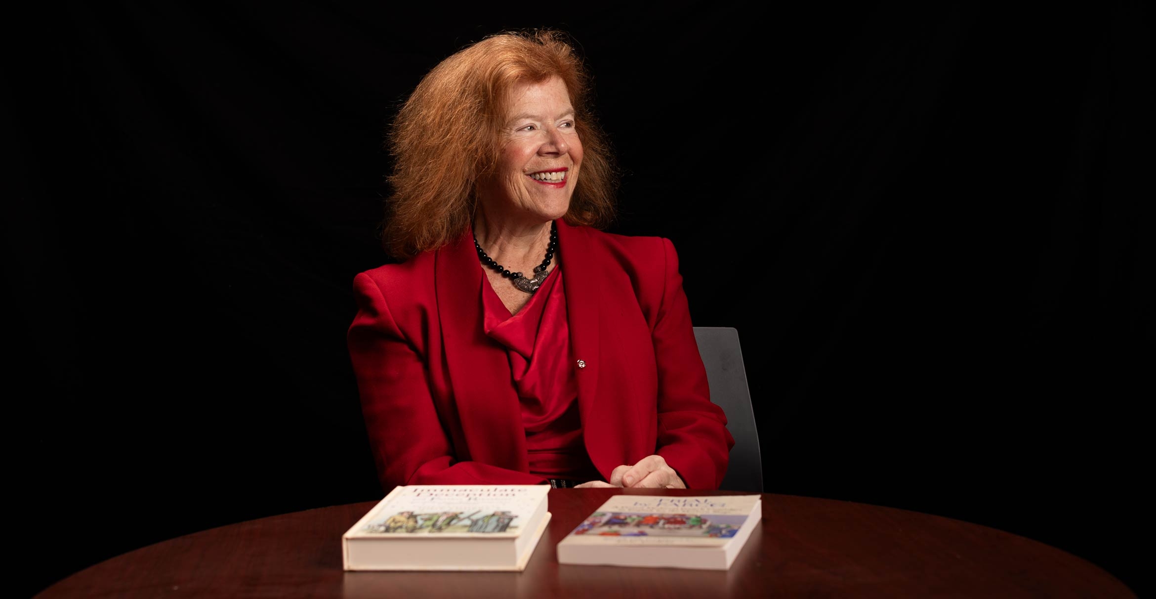 Portrait of professor Jody Enders with two books of translated French stage comedies