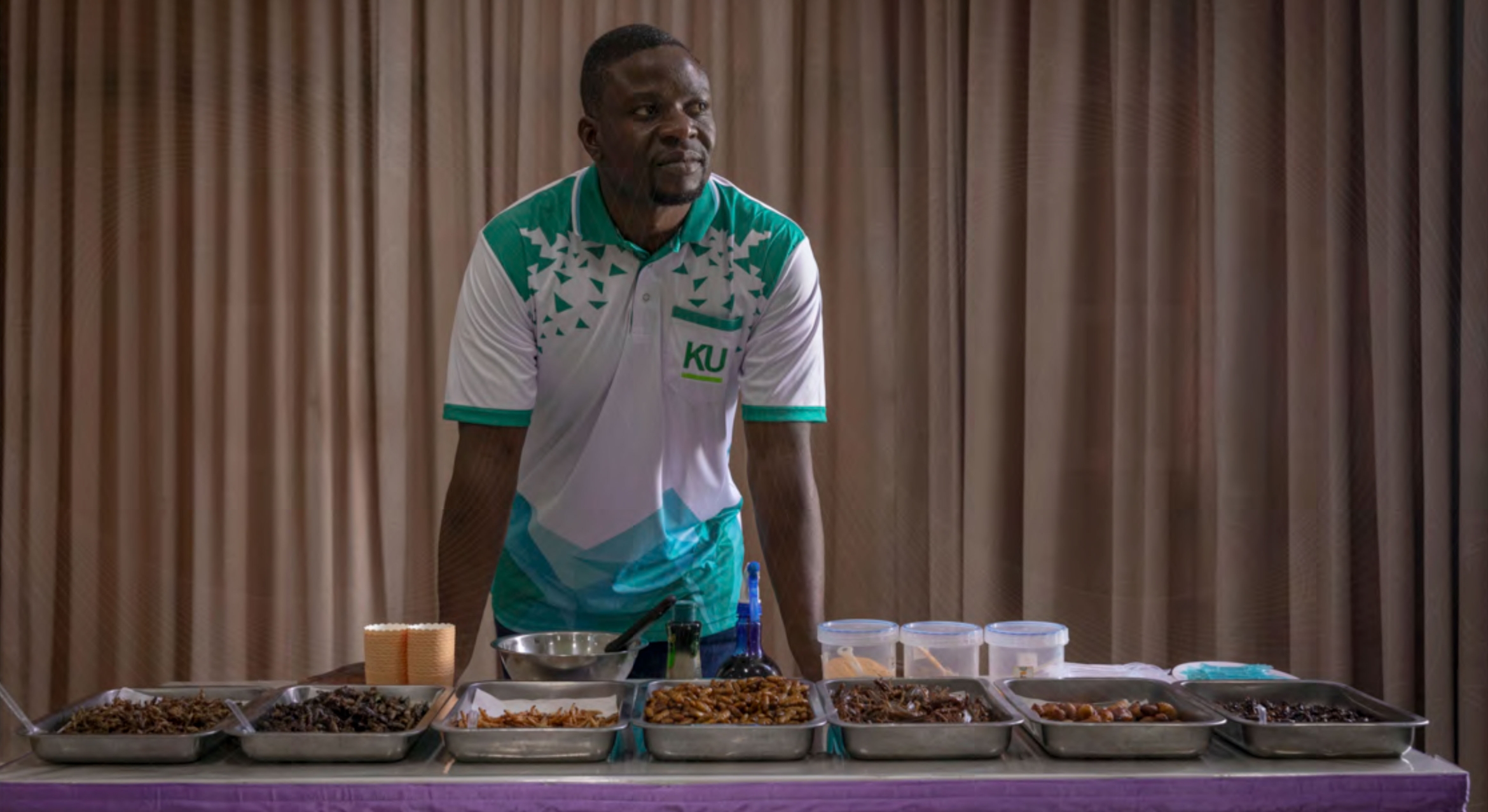 Black man with trays of different insects