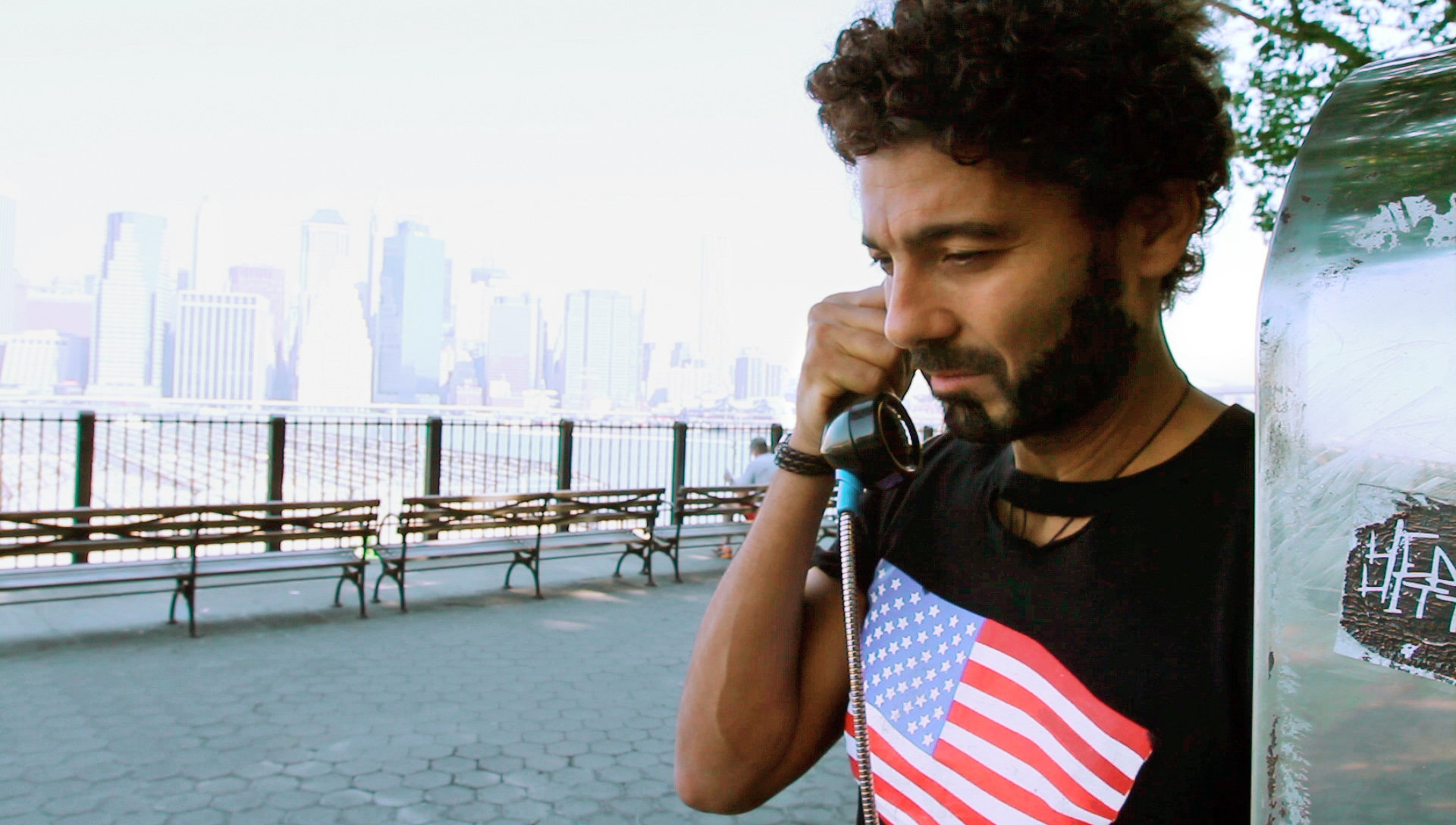 A promotional image from the film "The Citizen" depicts a man with dark hair on a payphone, with a NYC backdrop