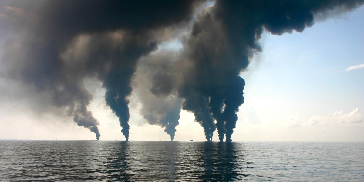 Smoke from beyond the horizon darkens the sky over the Gulf of Mexico.