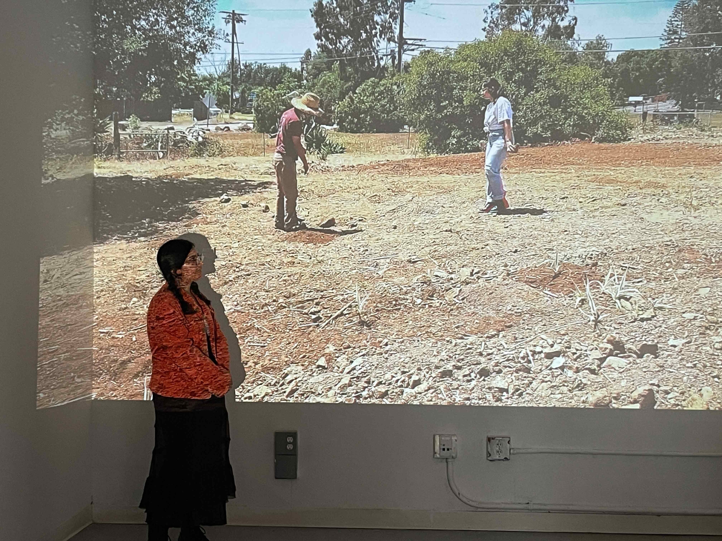 woman stands in front projection