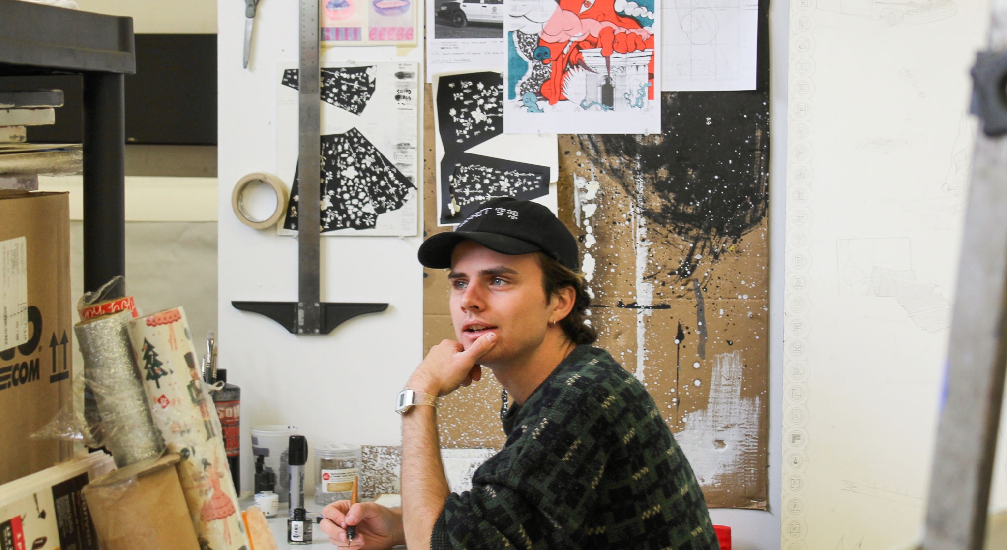 white man with hat sitting in art studio