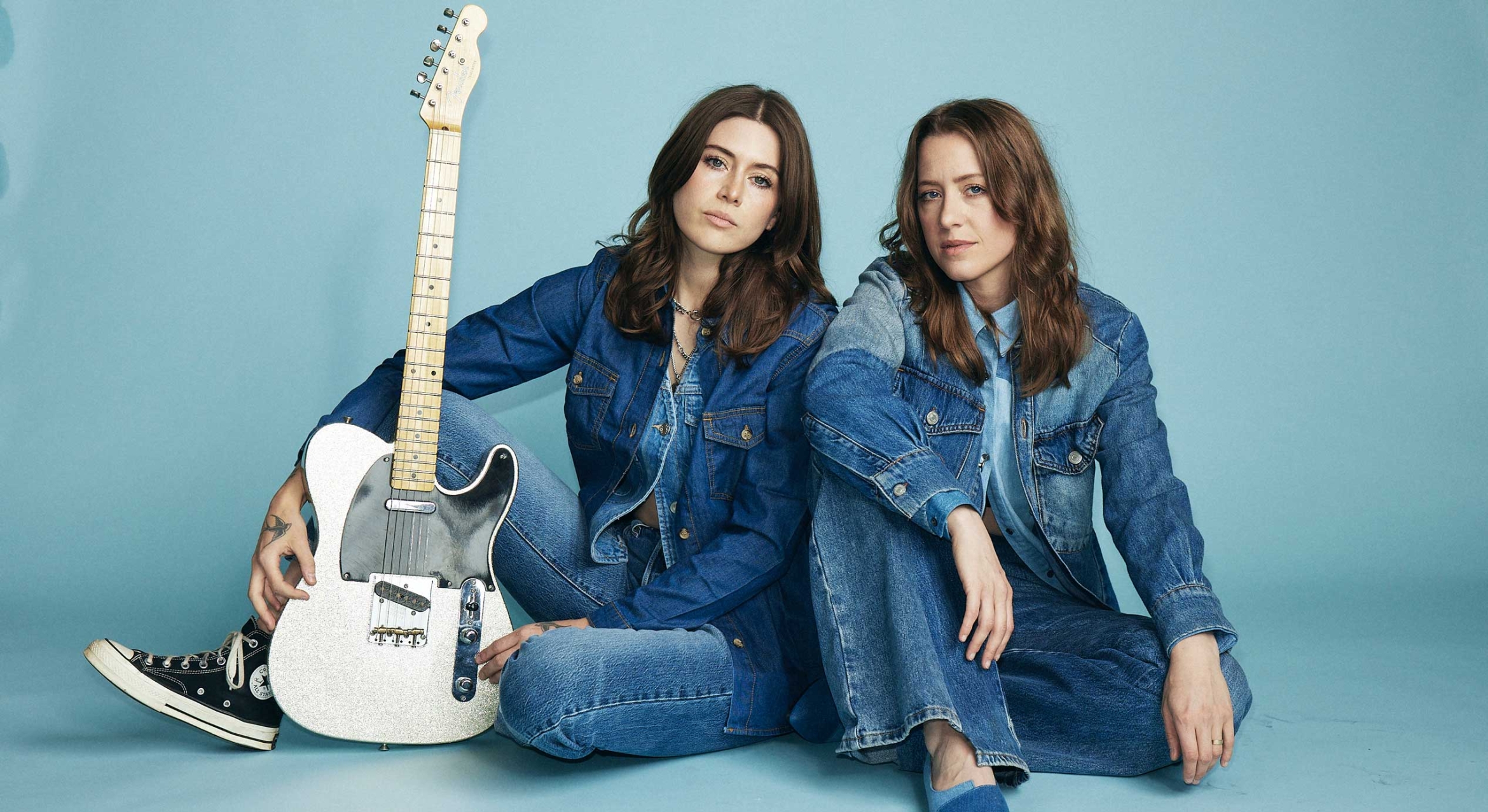 two women in denim with a bass