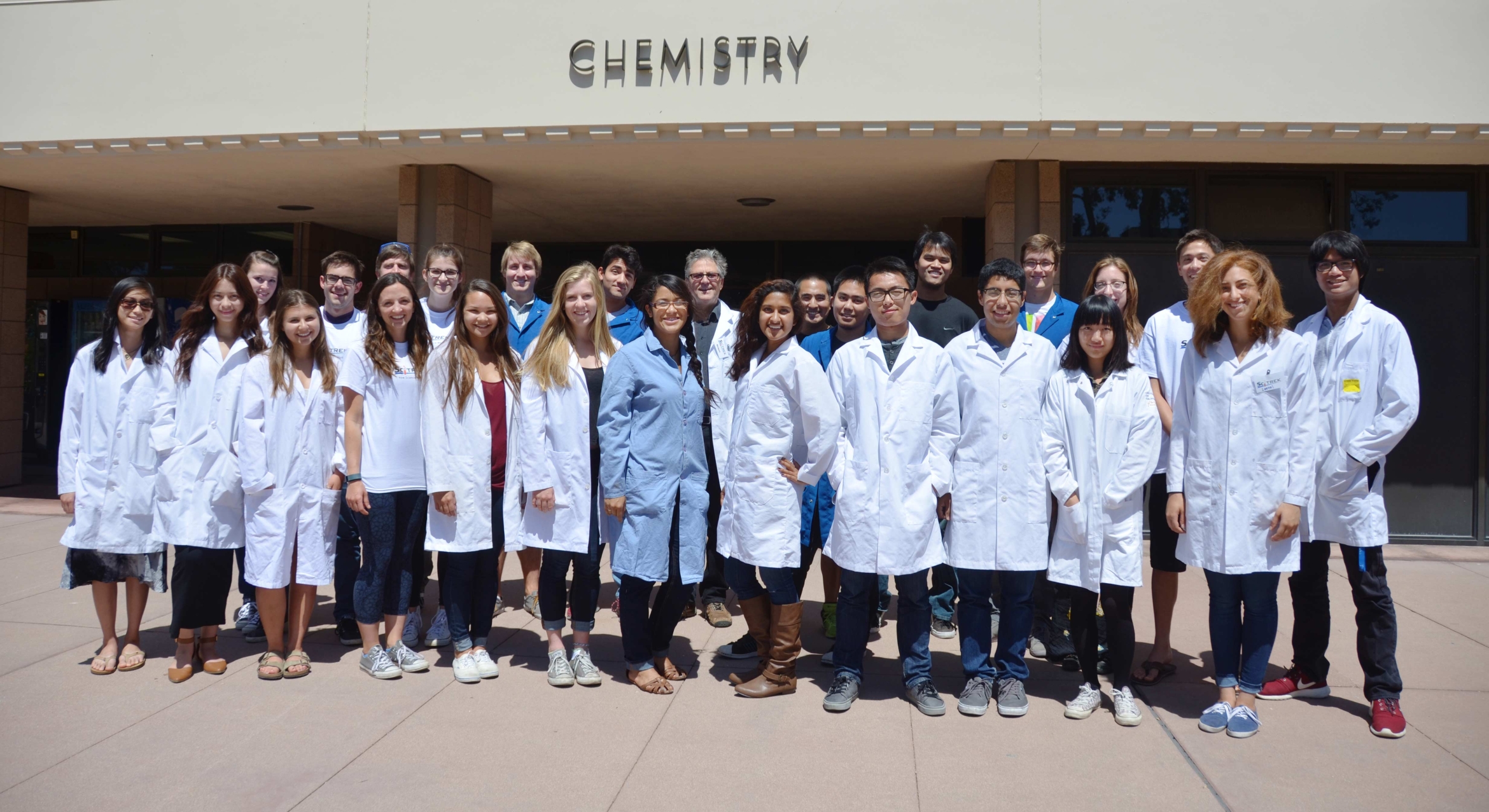 A group of  undergraduate volunteers pose in front of the chemistry building at UC Santa Barbara.