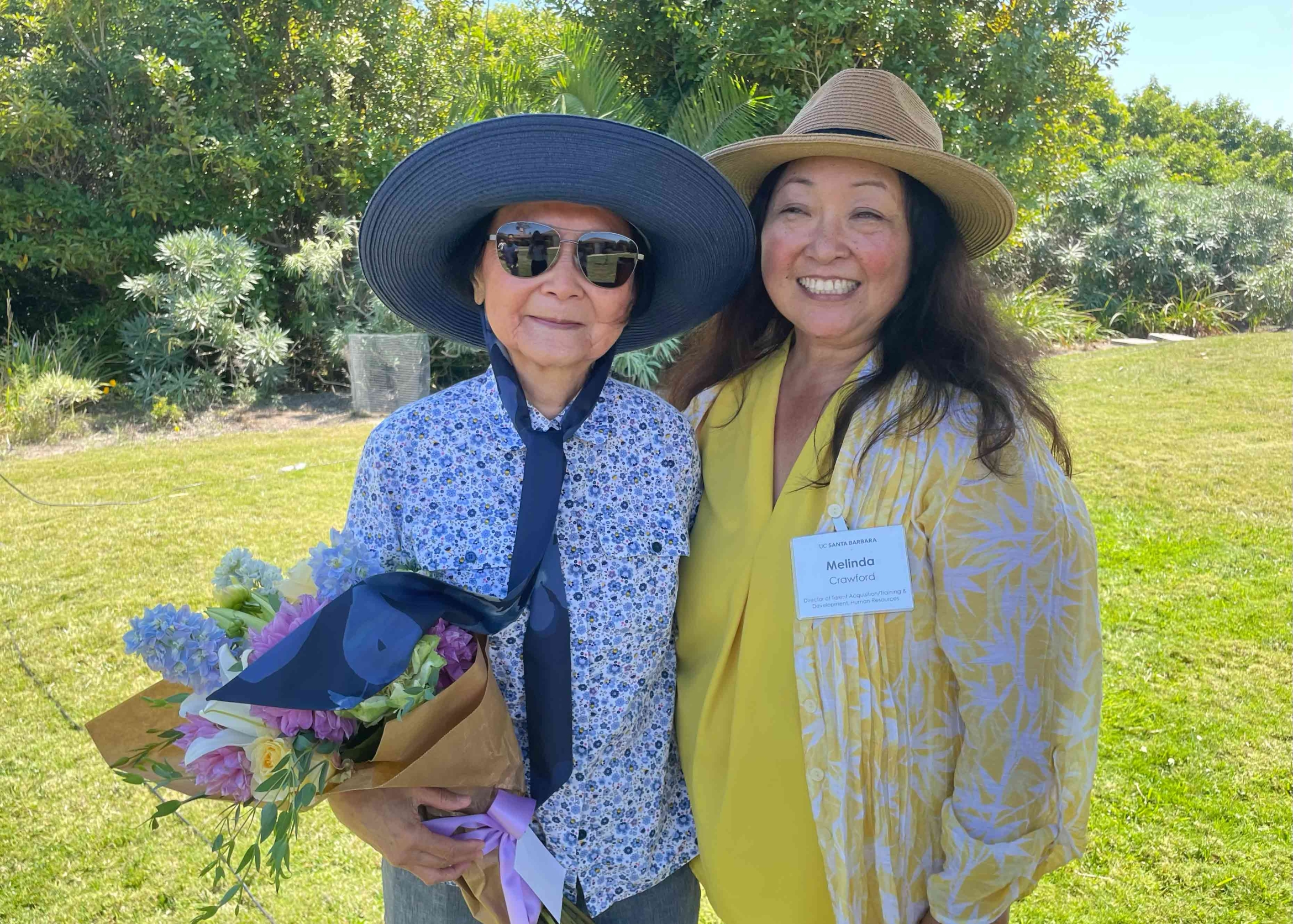 two women with sunhats embracing