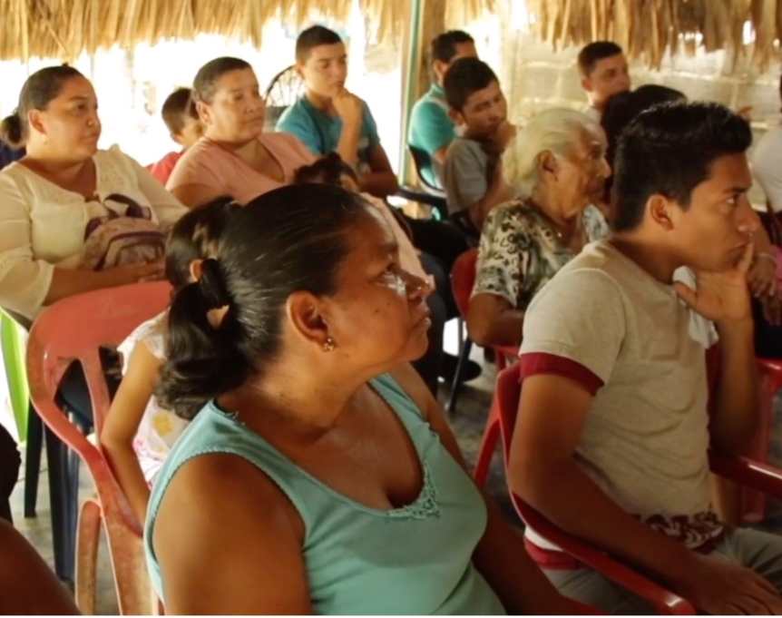 people sitting and listening to a speaker