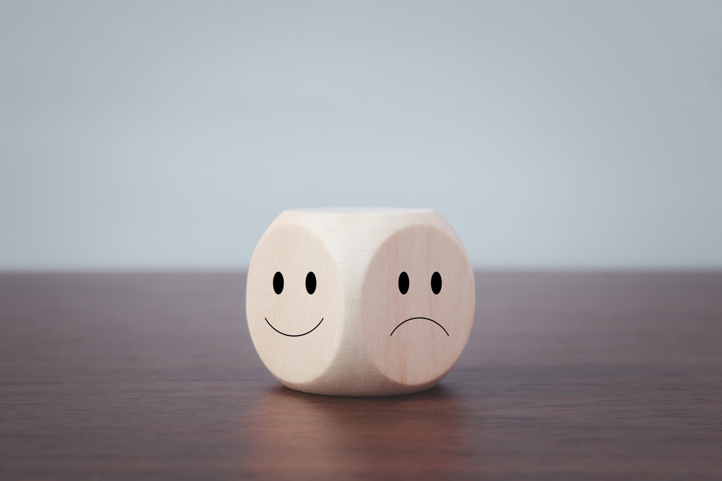 wooden block with one happy and sad faces