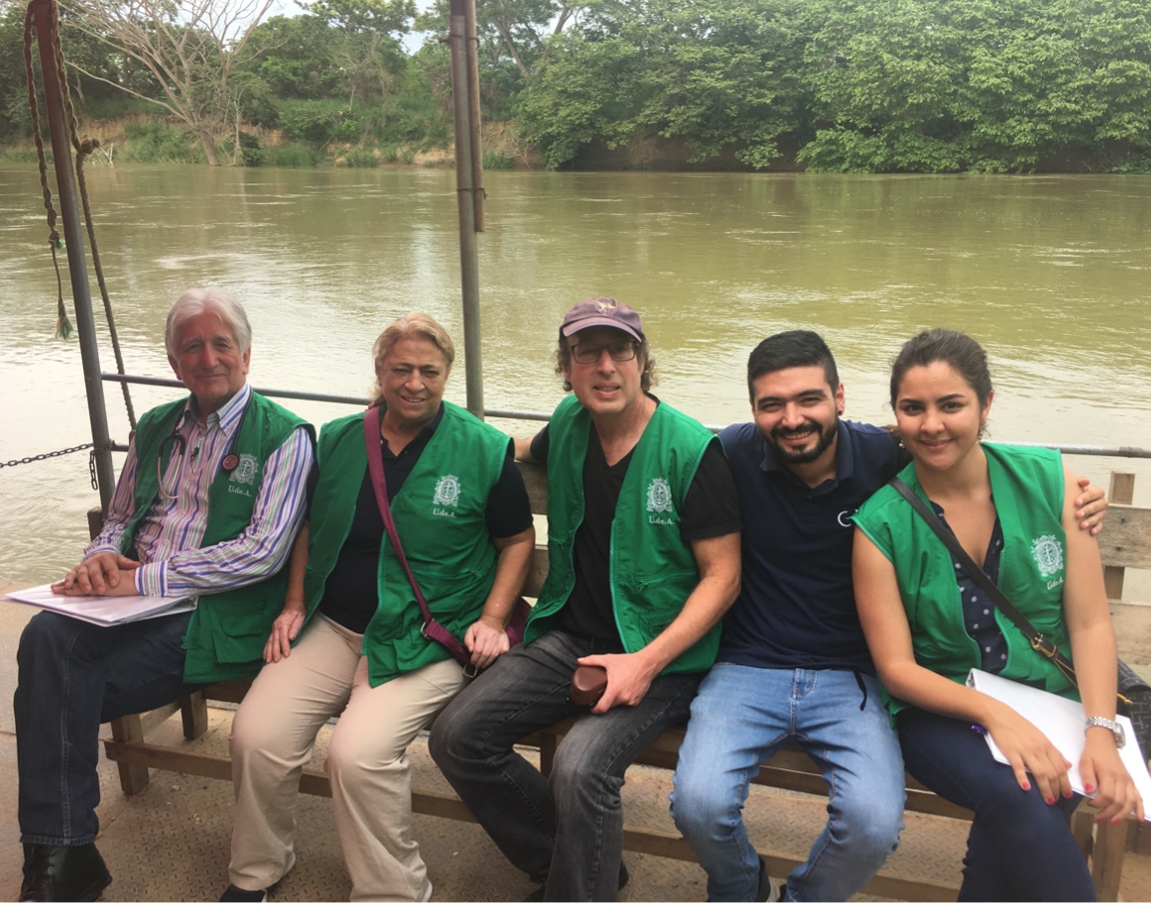 people sitting on a bench in a boat on a river