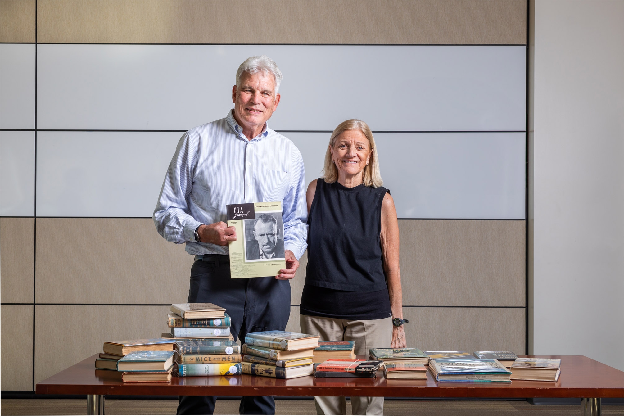 photograph of Mark Maxson and Mary Burchill with book collection donation to library