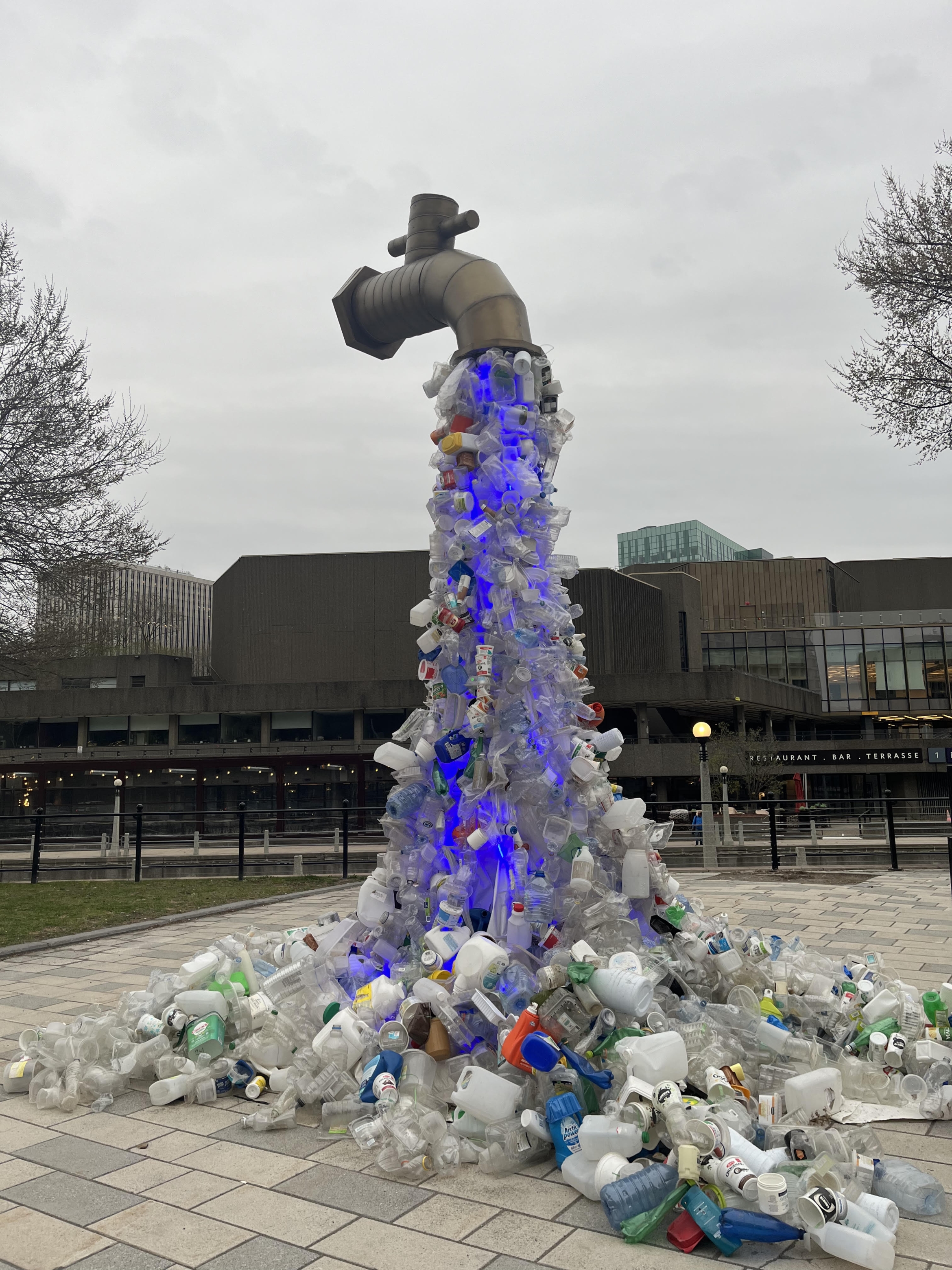 art installation featuring plastics flowing out of a giant spigot