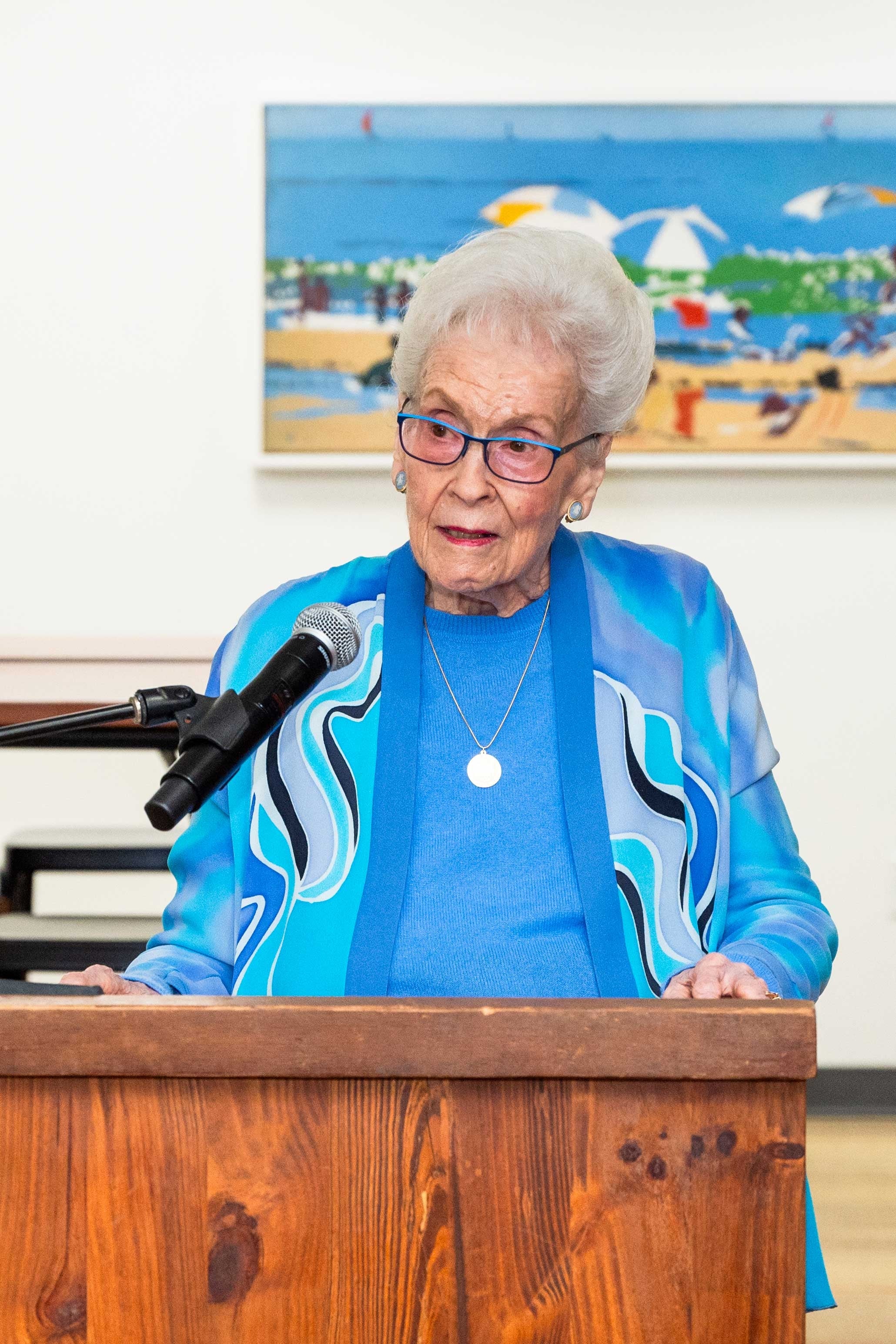 color photograph of Sara Miller McCune standing at a podium 