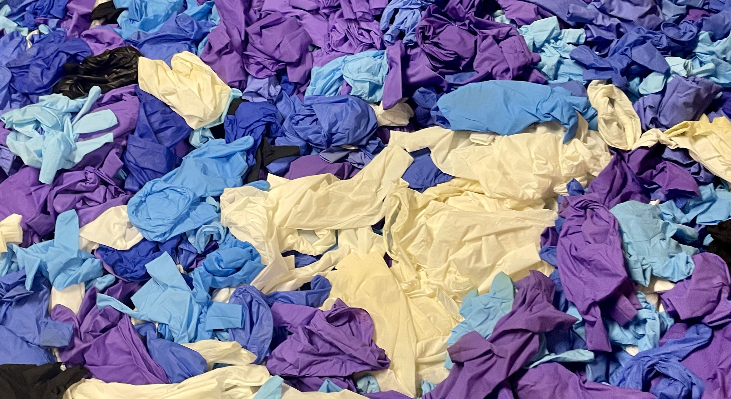 Hundreds of pairs of blue, purple and white plastic gloves