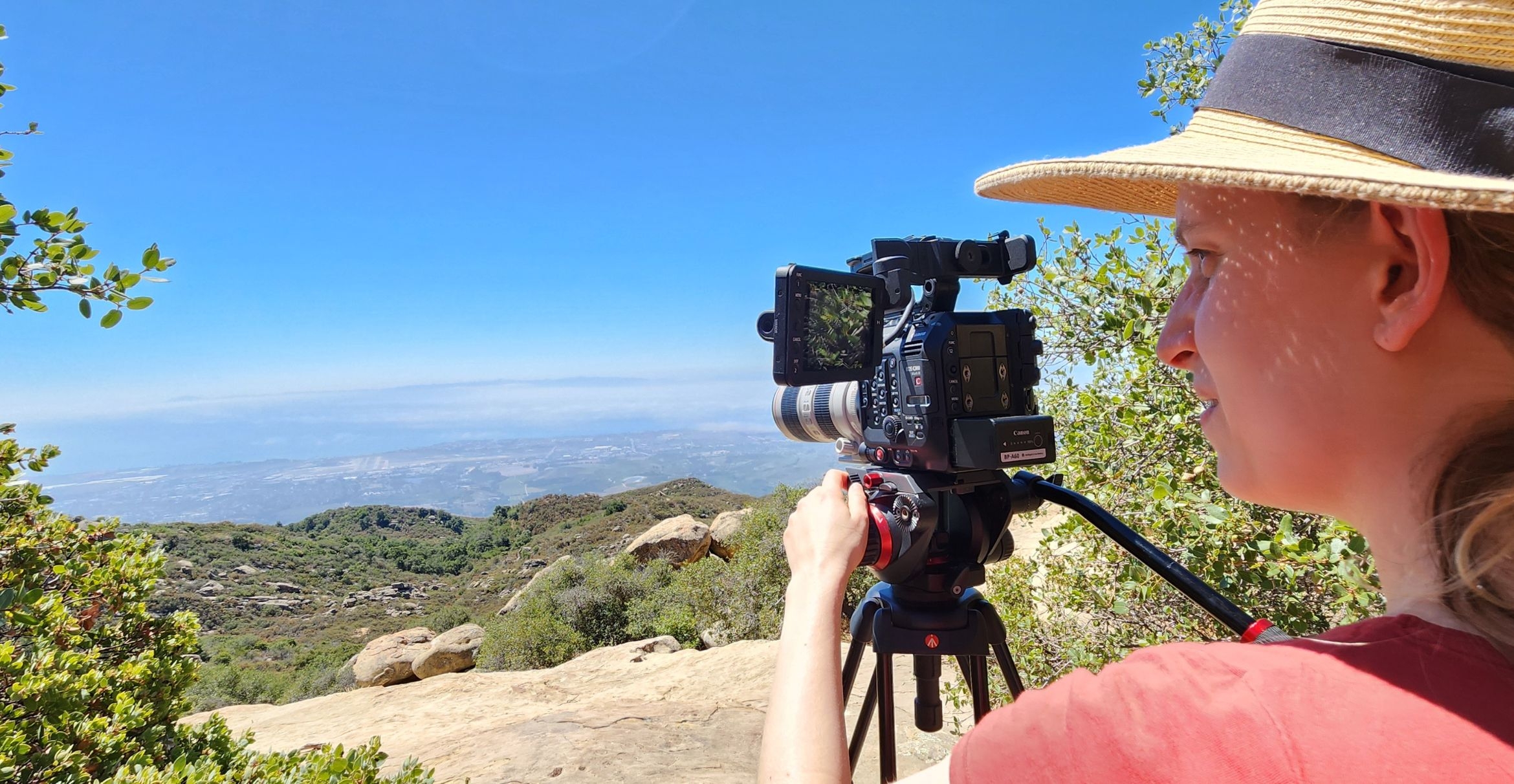 a women with a digital camera records the landscape from an overlook