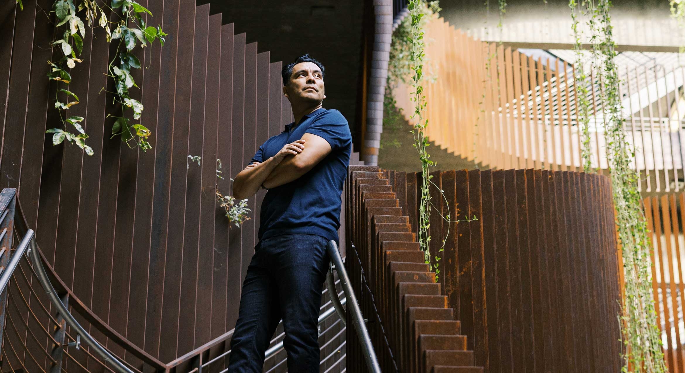 color photograph of writer Manuel Munoz standing on a staircase 