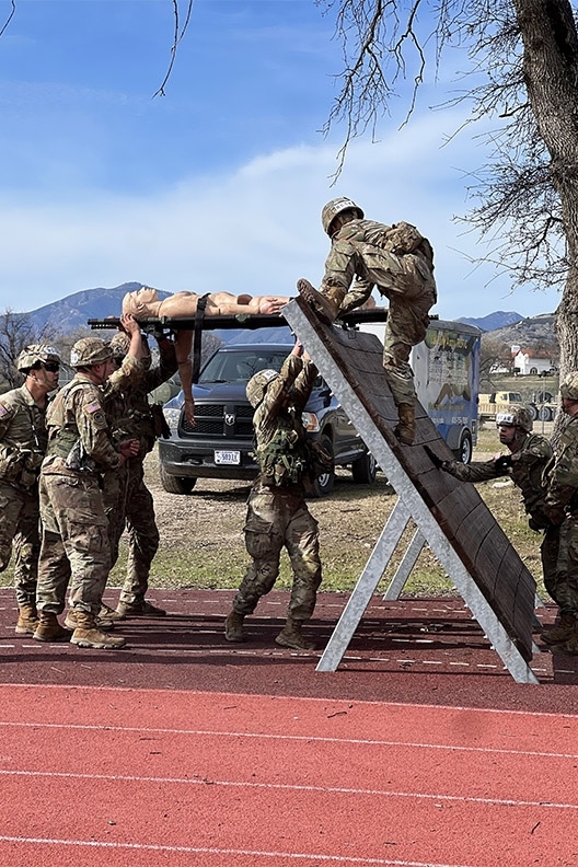 cadets carry a casualty dummy across an obstacle course