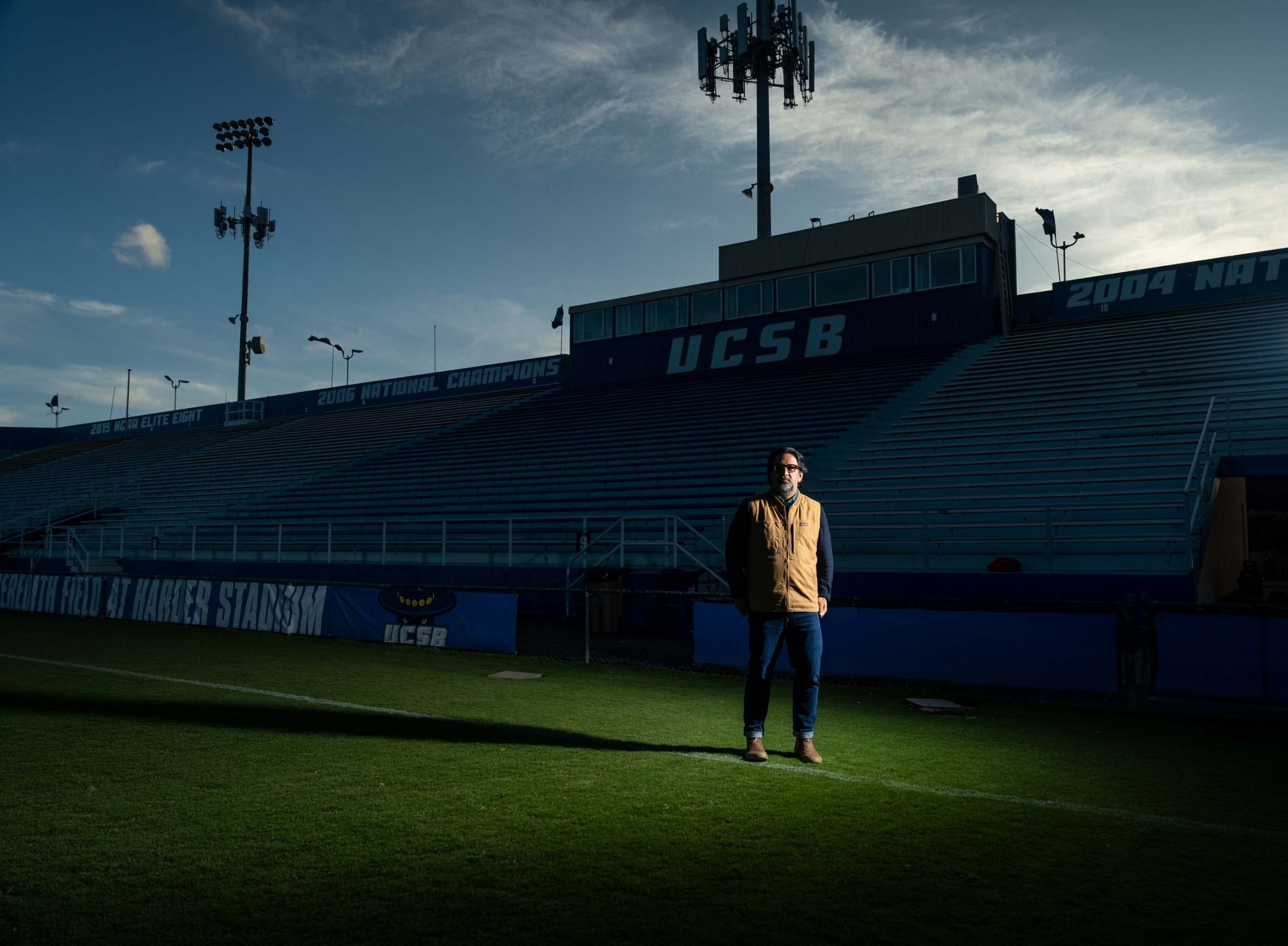 man of East Asian descent in sports field with dramatic light