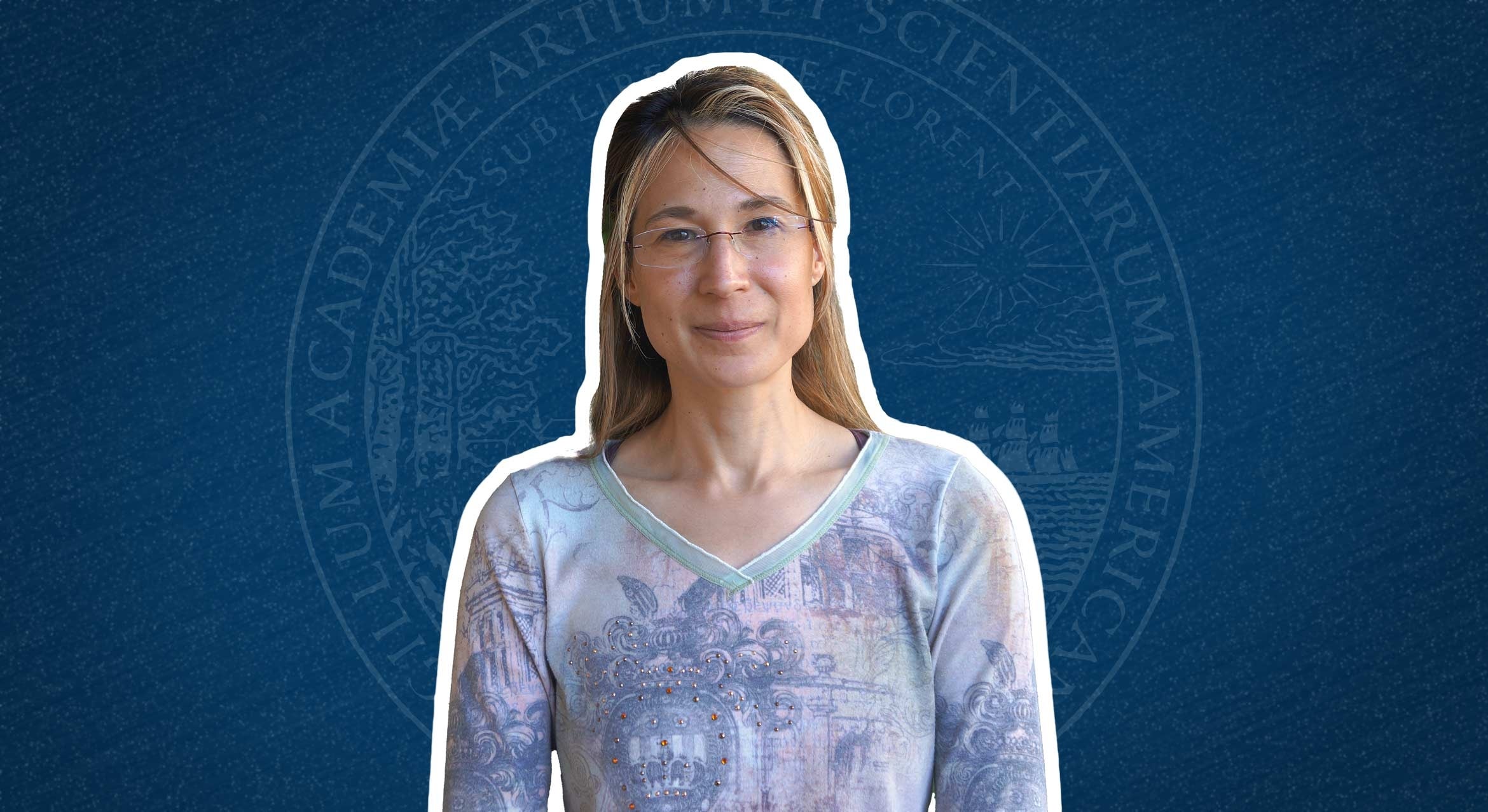 Irene Beyerlein in front of the American Academy of Arts and Sciences seal