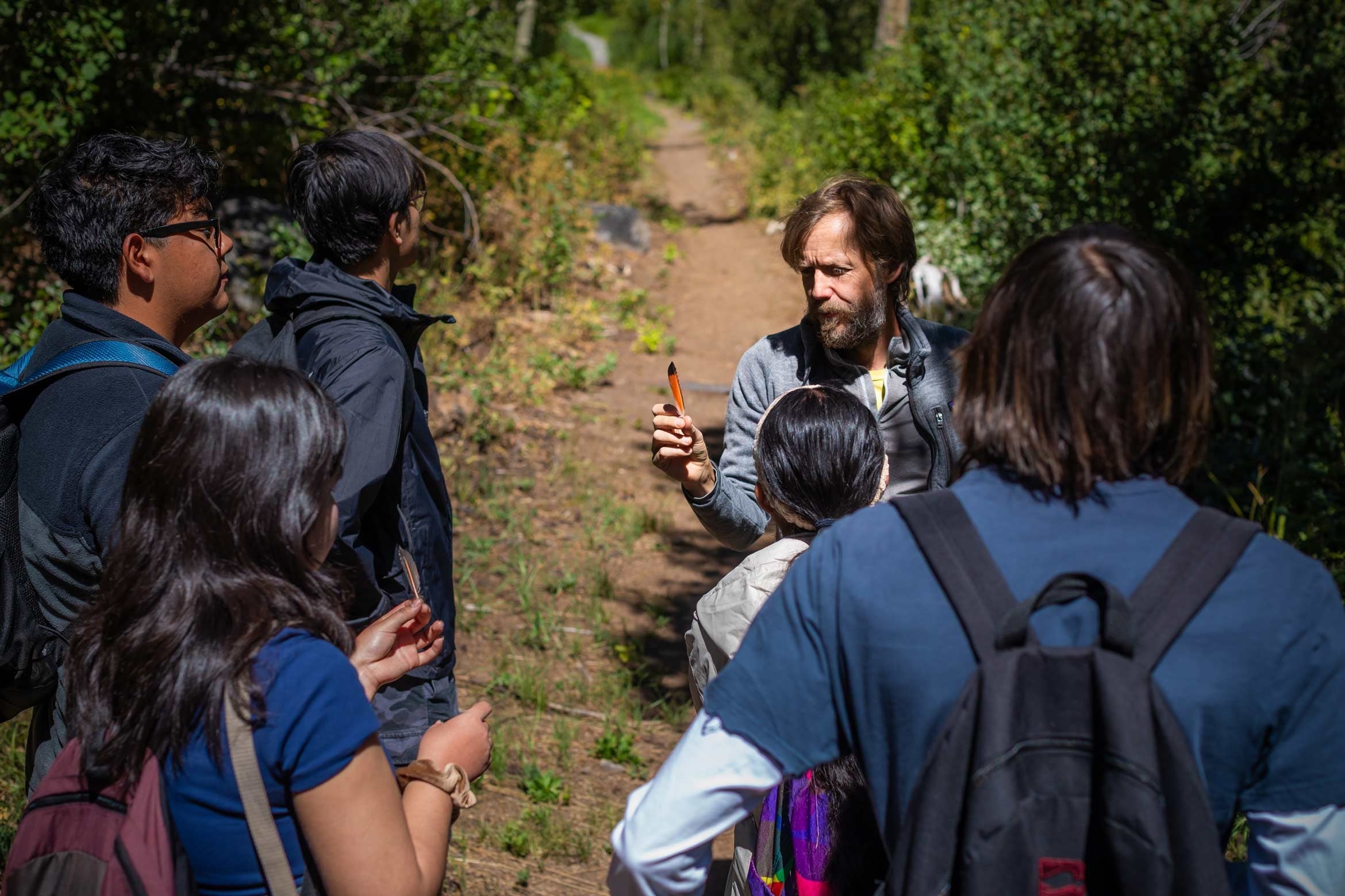 Professor Doug McCauley showing a bird feather to students