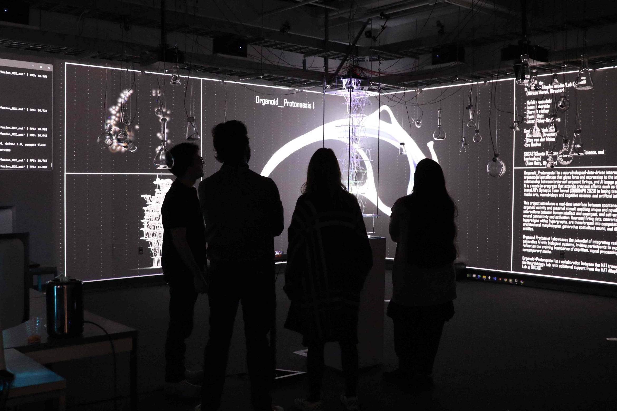 people silloueted looking at screen with visualiztions