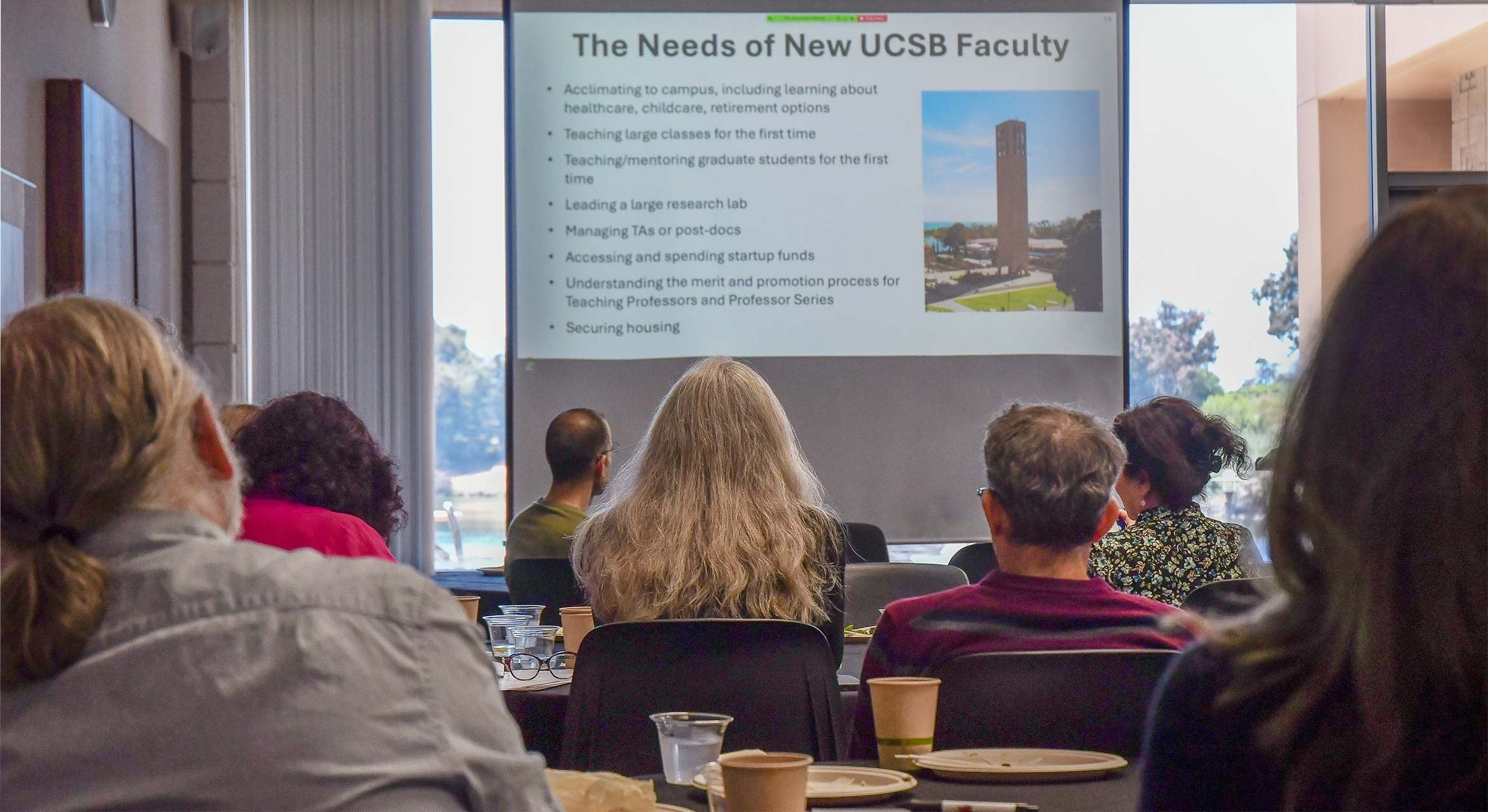 View from behind of people watching a presentation