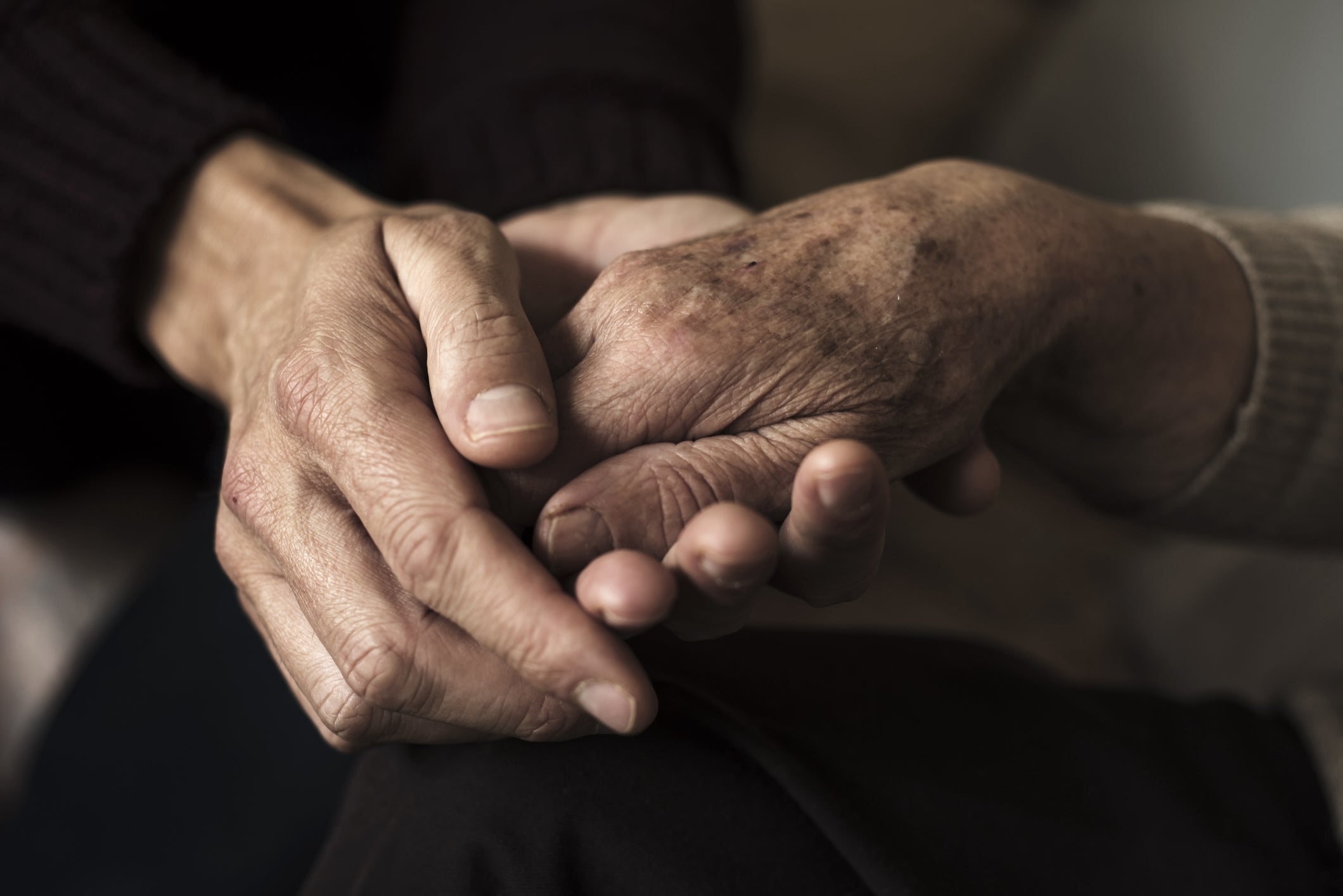 a pair of hands holding an aging hand